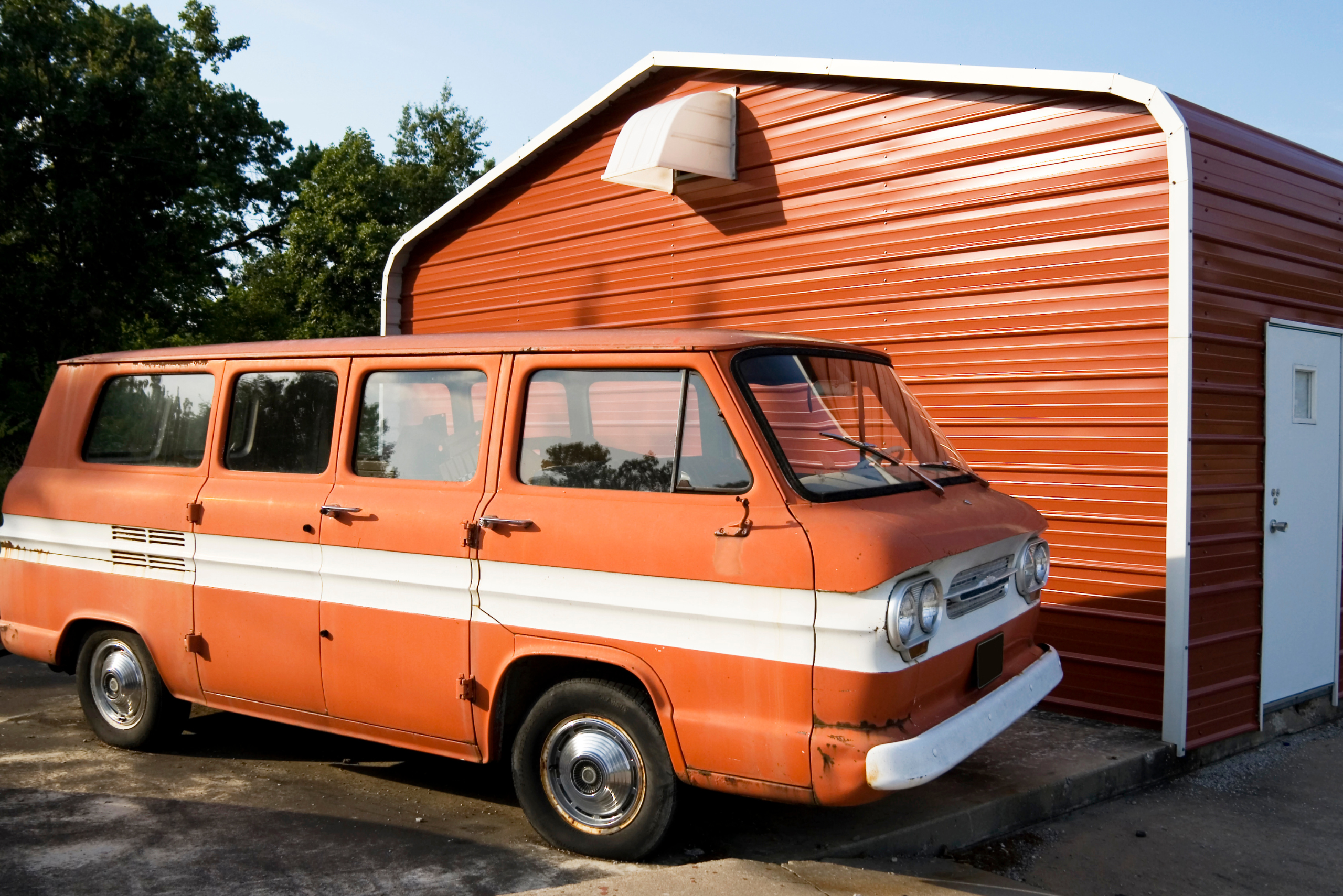 Red camper van by red shed.