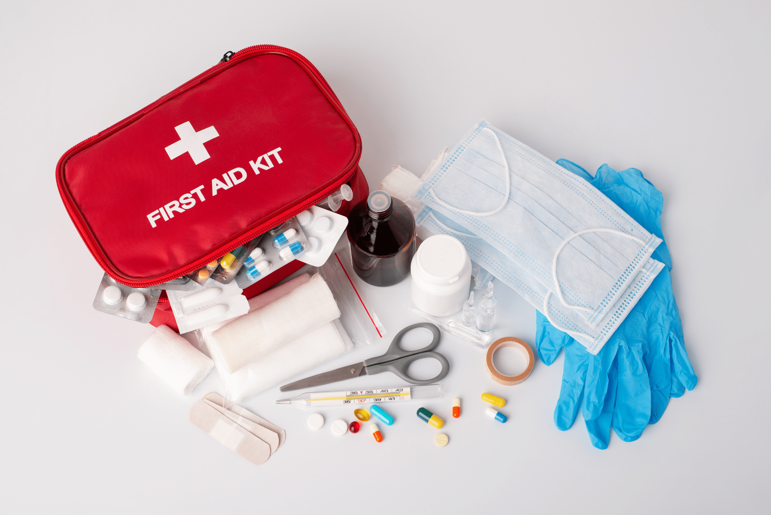 Red first aid kit with its contents outside of it.