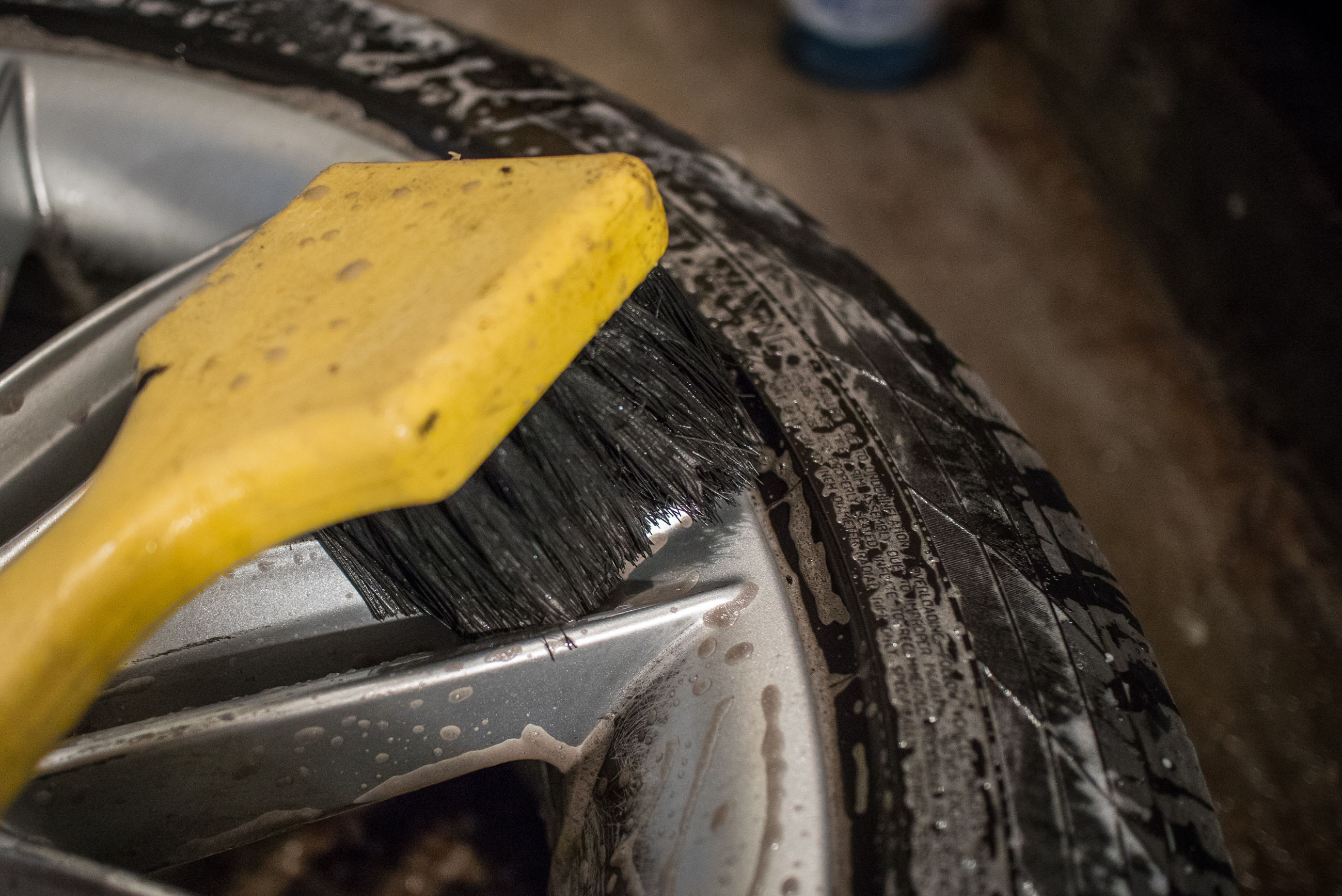 Scrubbing car wheel with soft plastic brush.