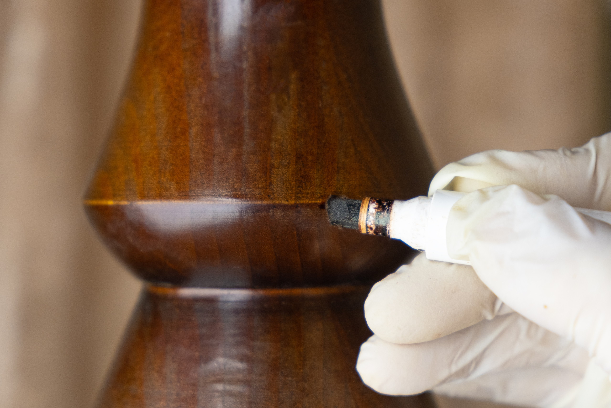 Hand wearing glove using a furniture marker.