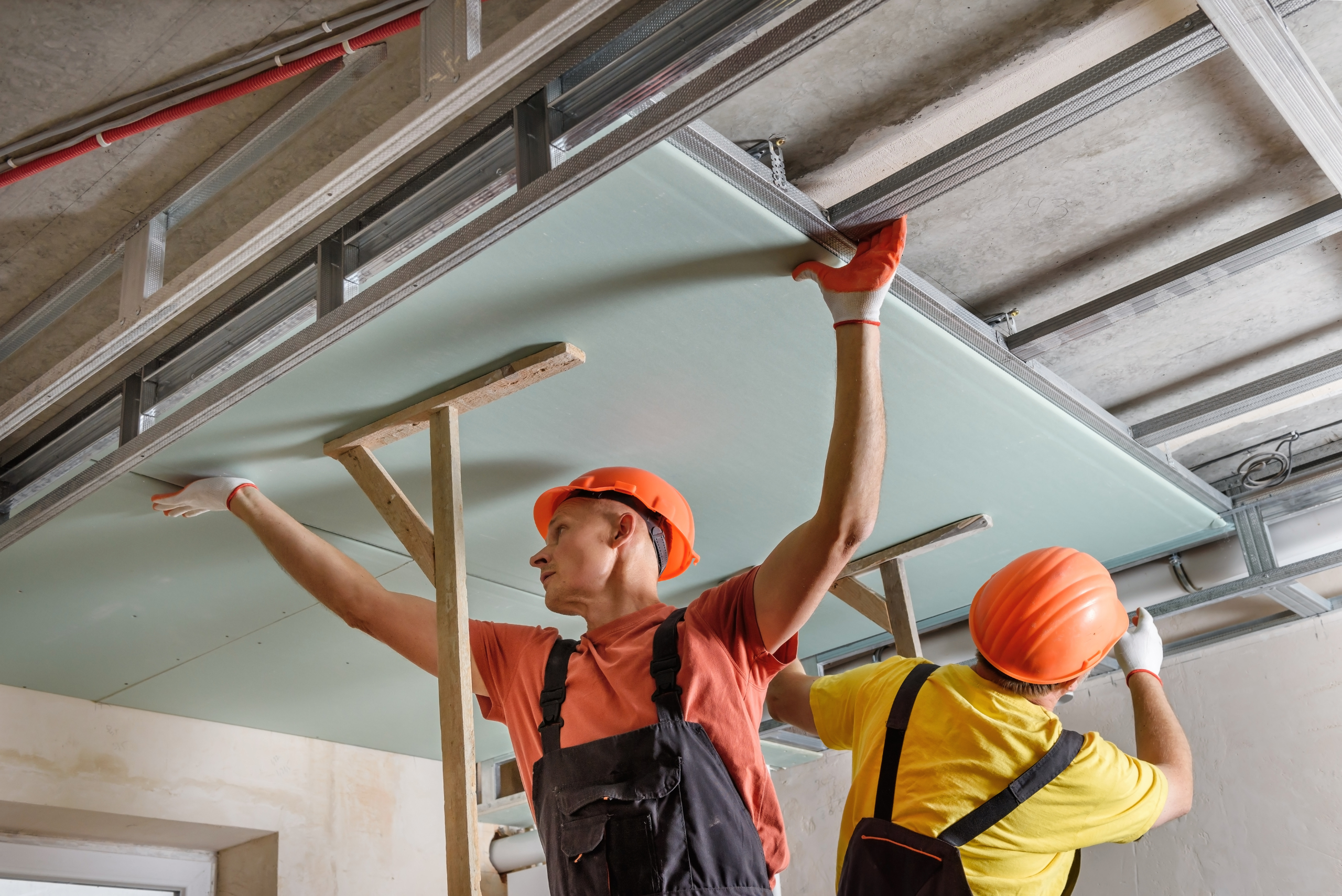 Two men installing drywall.