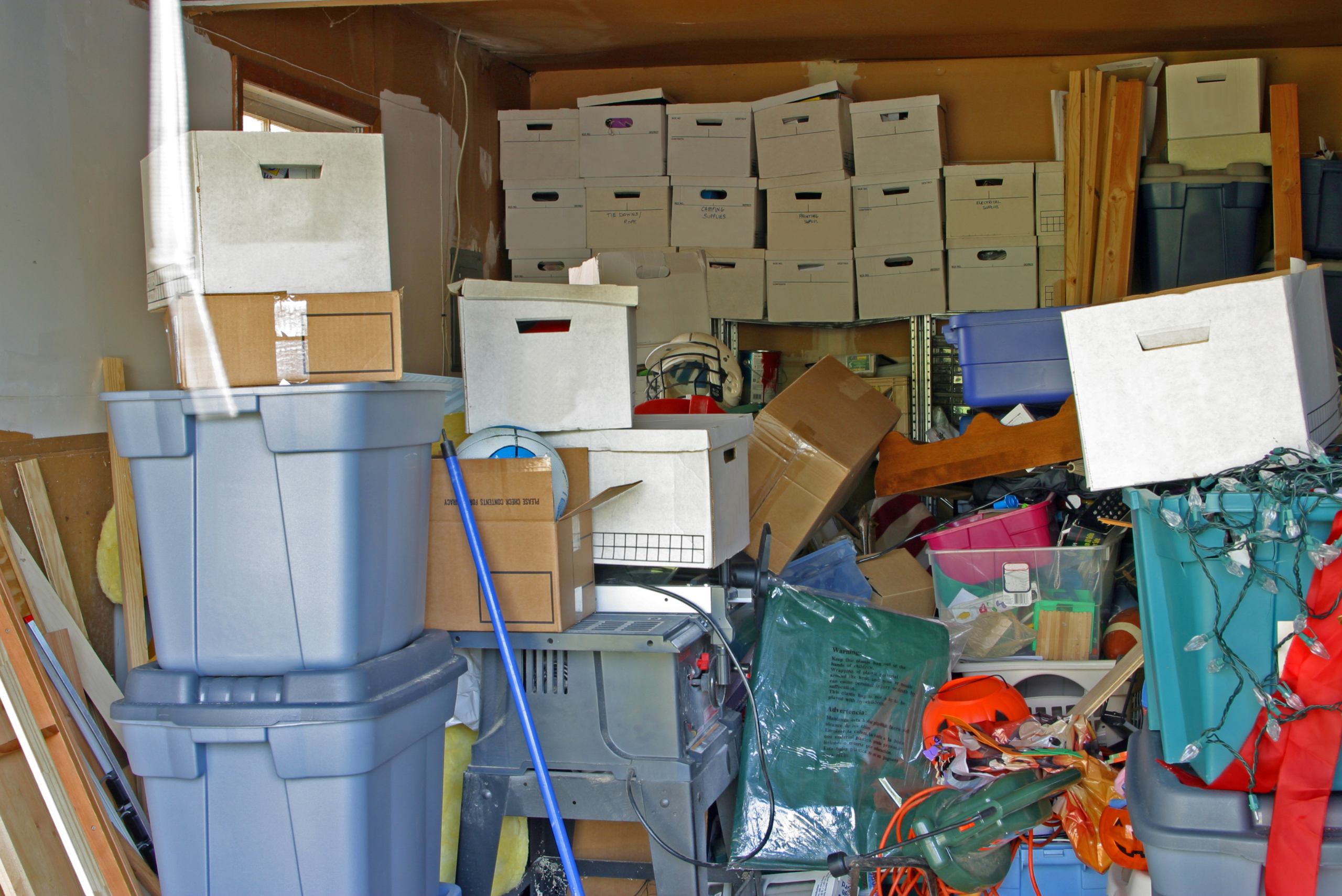 Old building materials on the side in a cluttered garage.