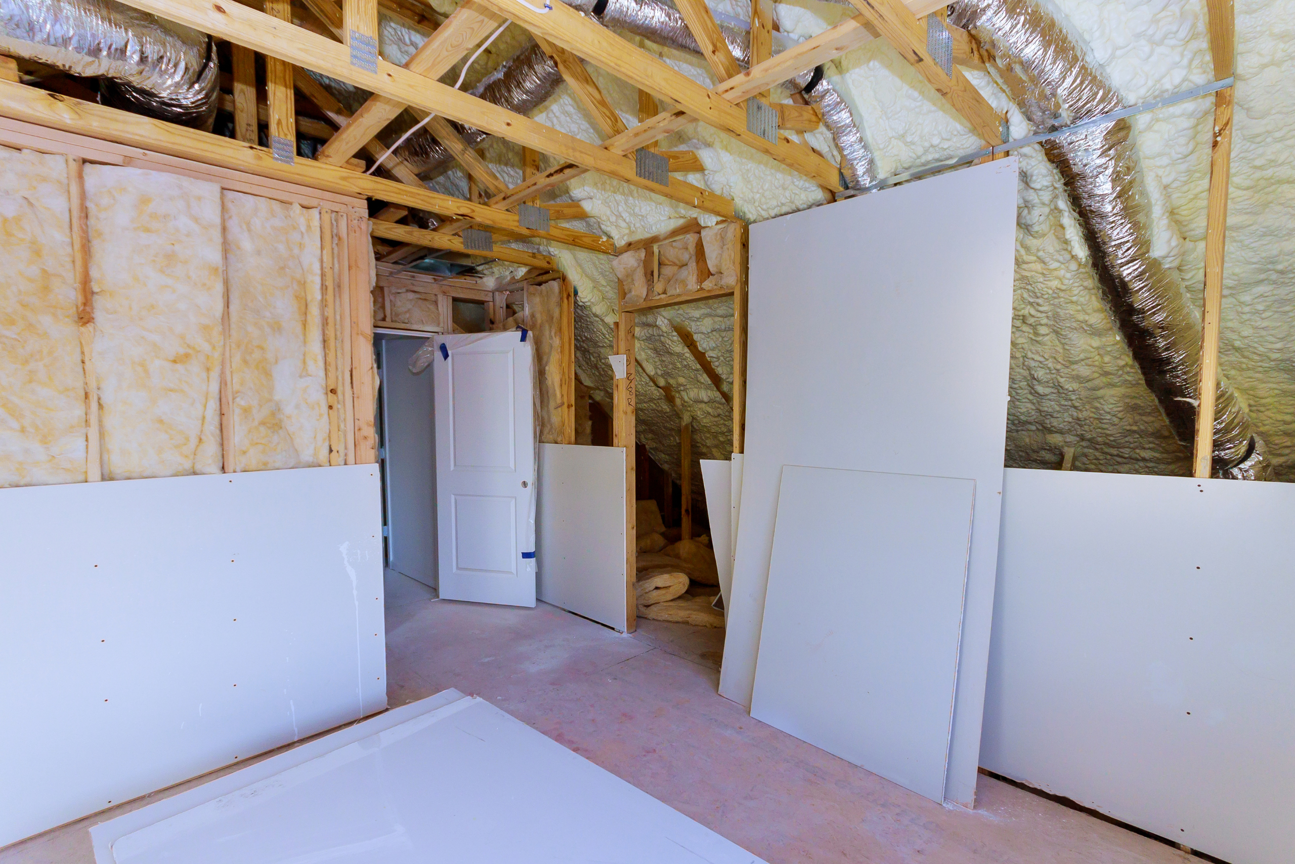 Drywall sheets in an unfinished room.