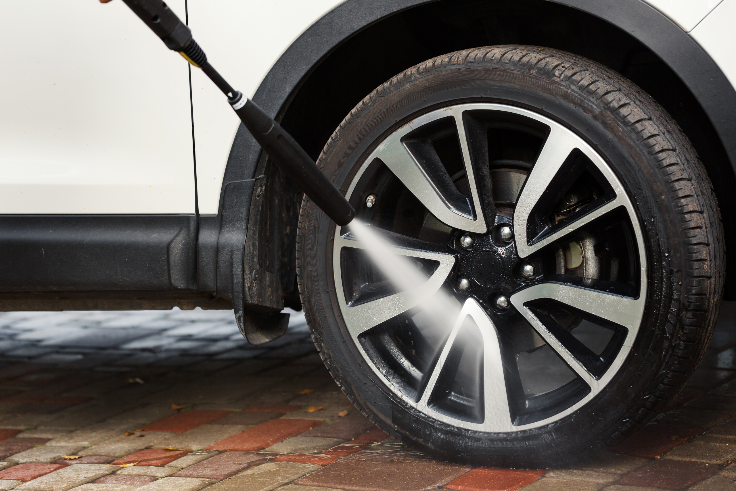 Pressure washing car wheel.