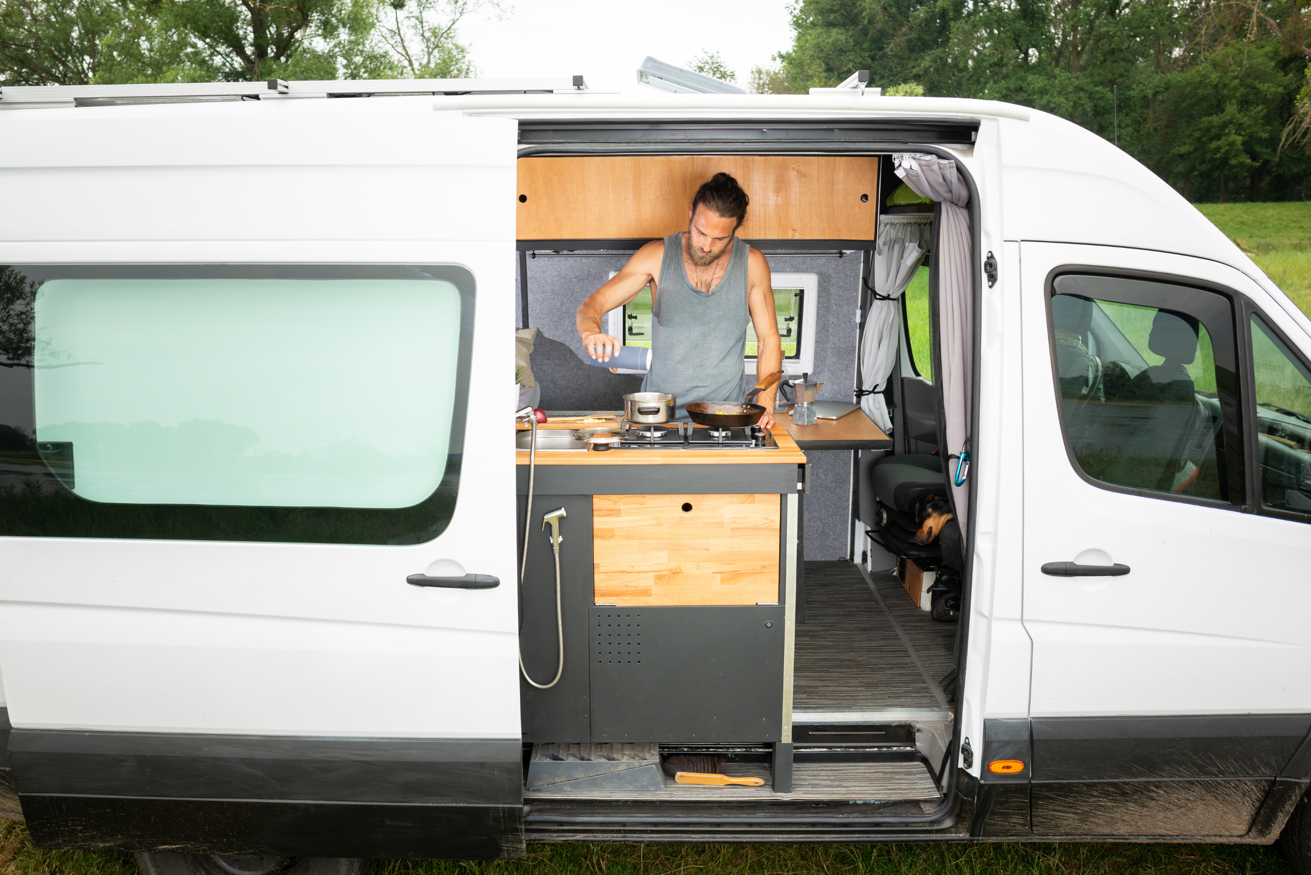 Man cooking inside a camper van.