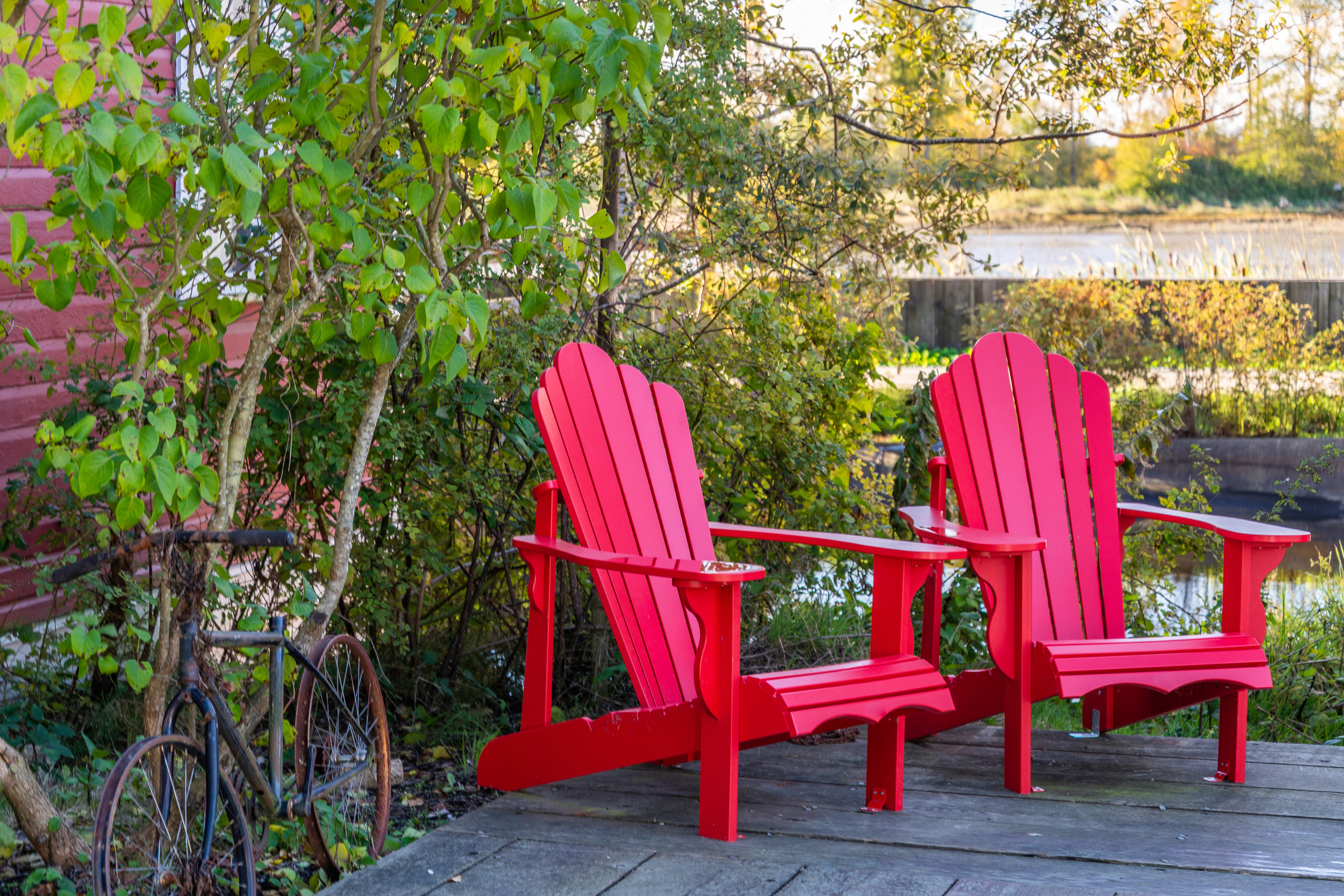 Two red Adirondack chairs.