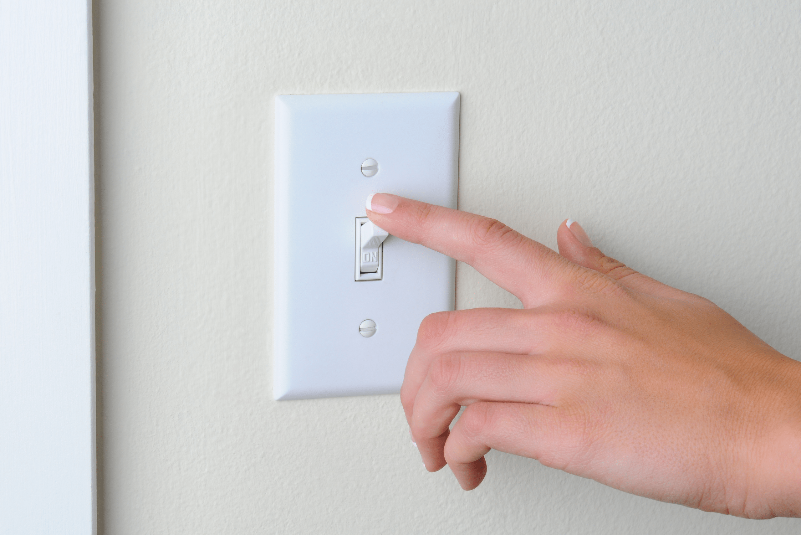 Turning off light switch.