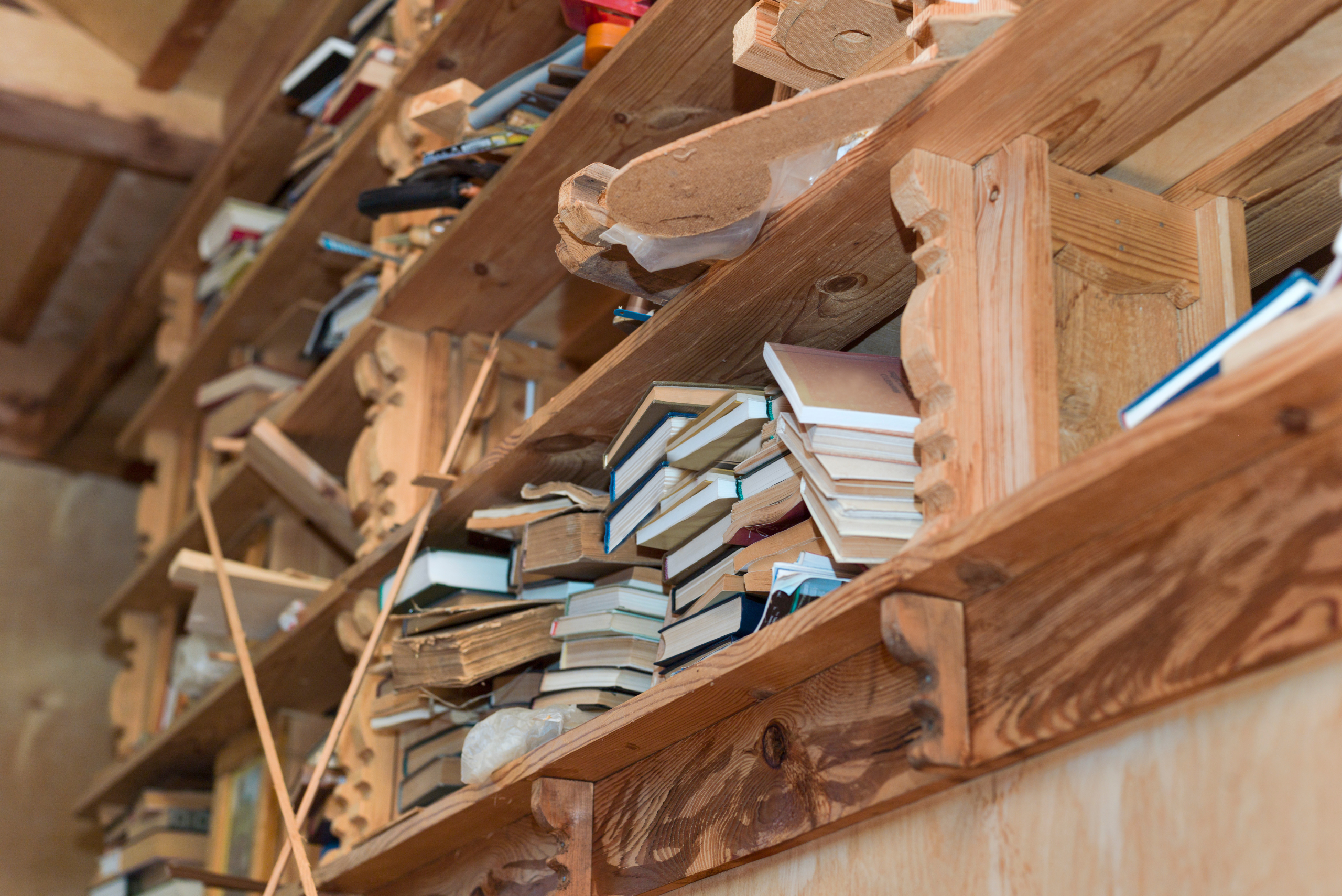 A wooden shelf full of books.