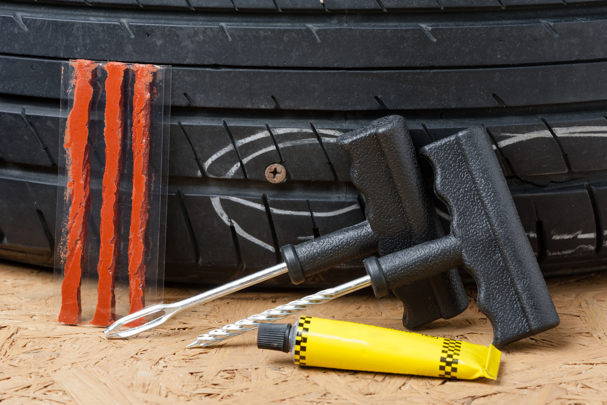 Tire repair kit flanked by a tire.