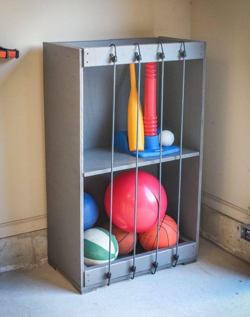 Bungee cord holding balls inside a cabinet.