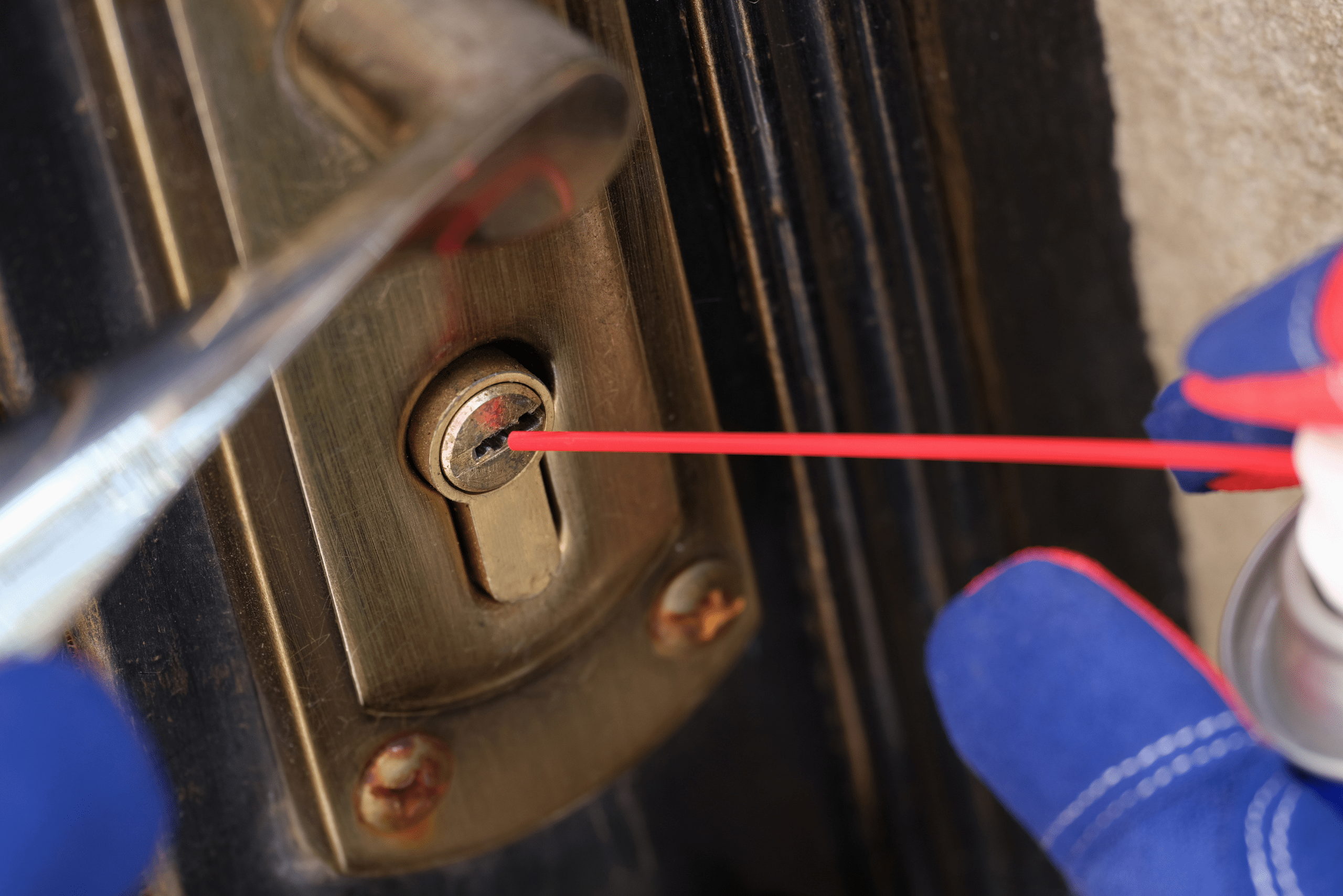 Closeup of lubricant being sprayed inside the lock.