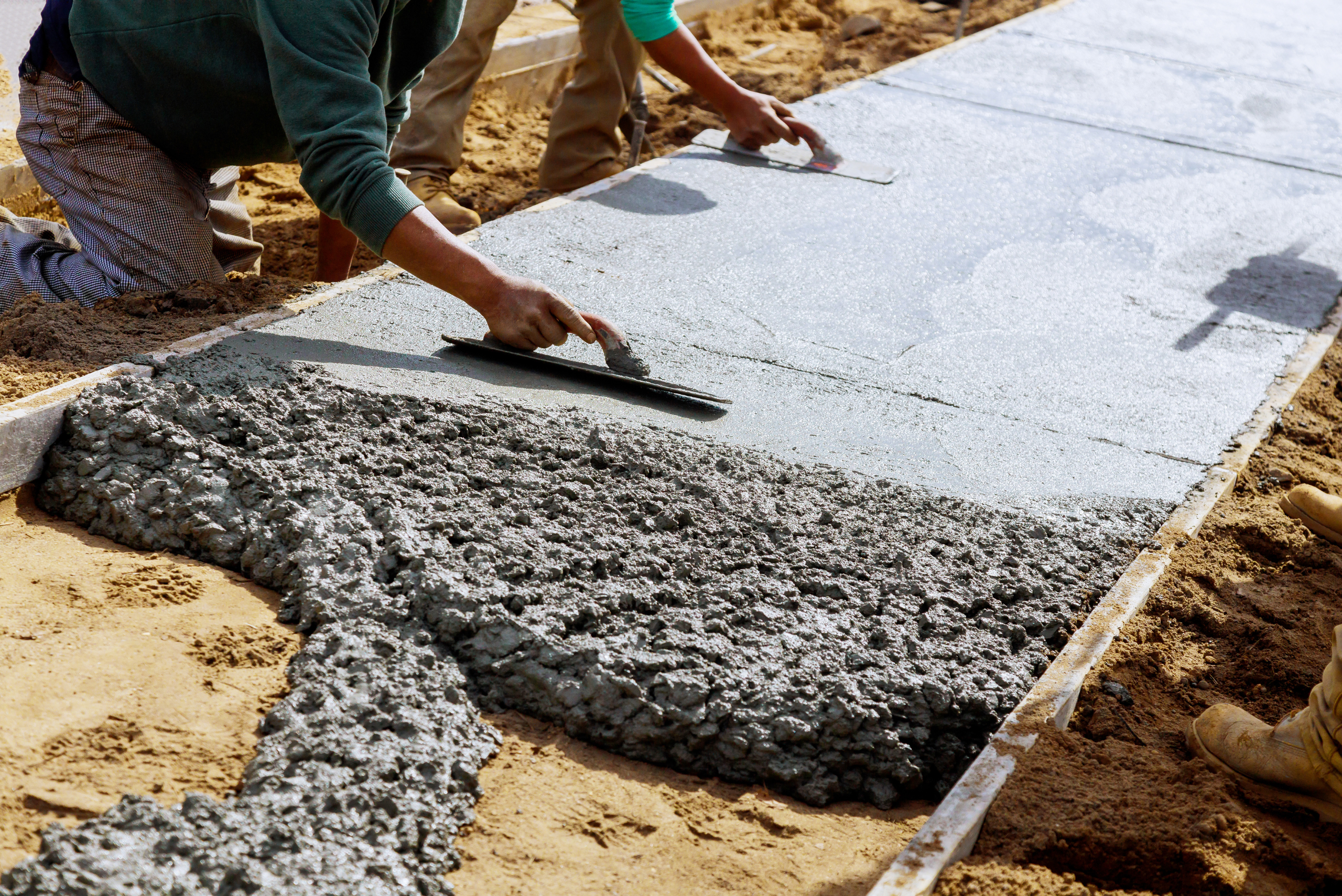 Worker smoothing out concrete pour.