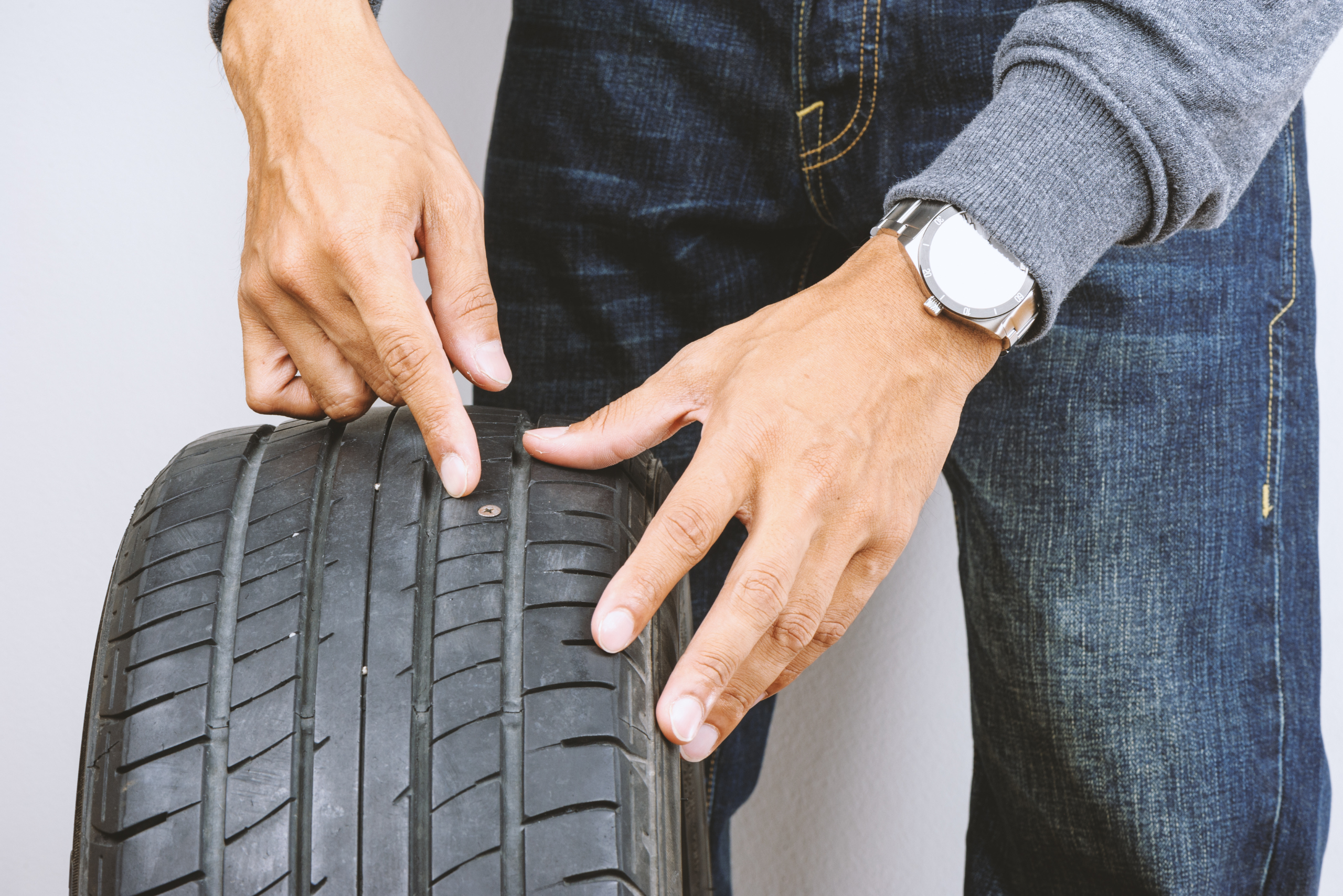 Man using a tire plug kit.