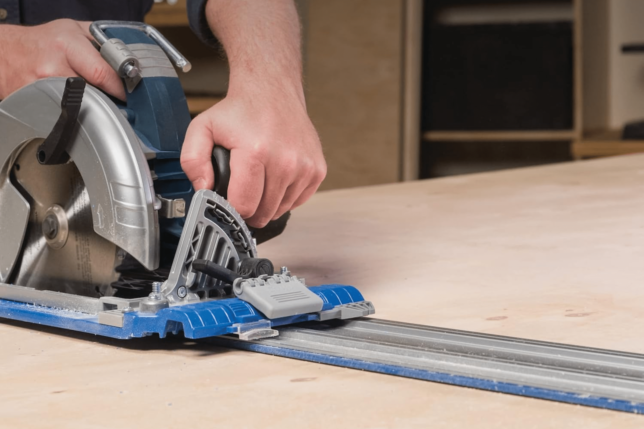 Person using a track saw on wood.