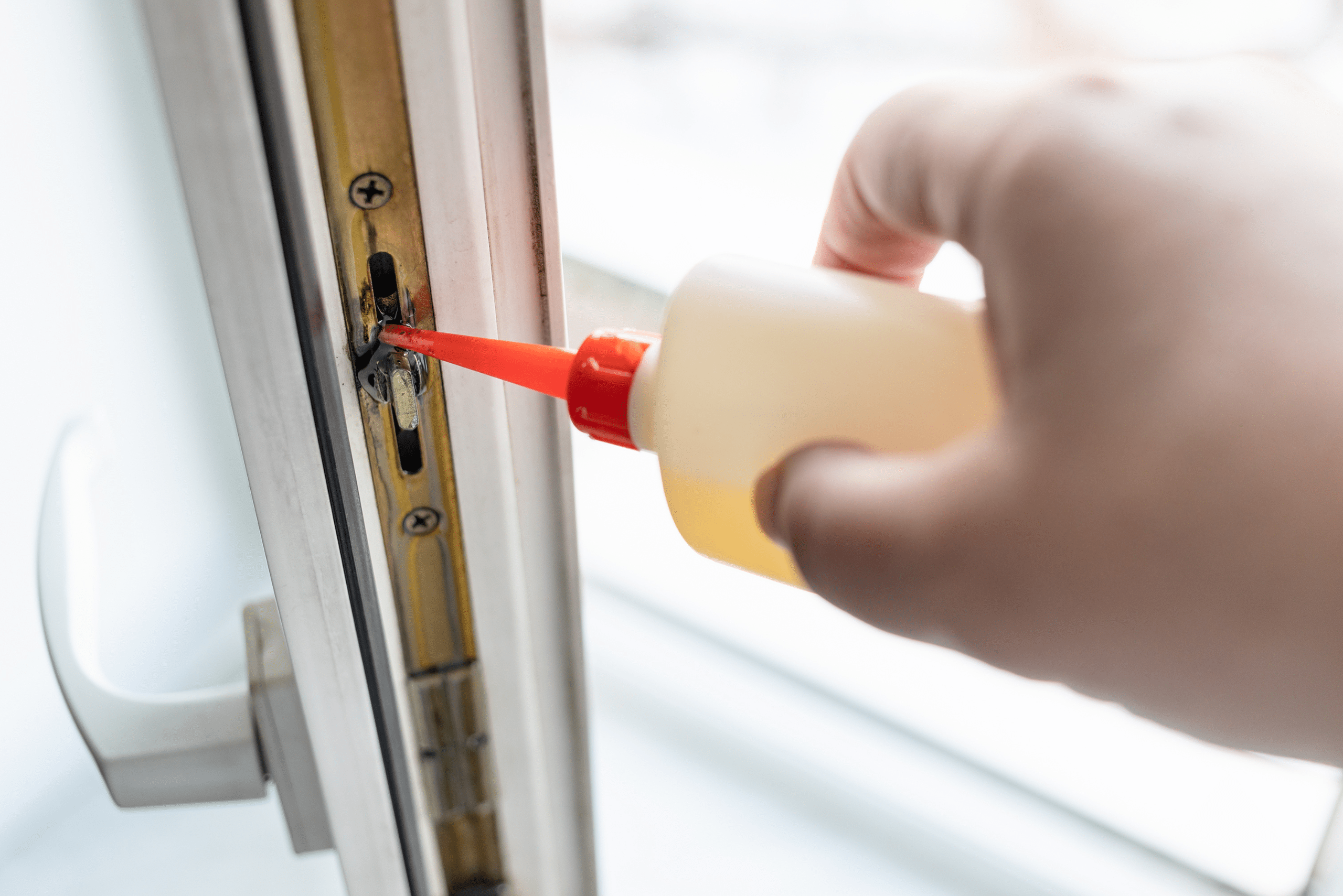 Person's hand using a squeeze bottle to lubricate window.