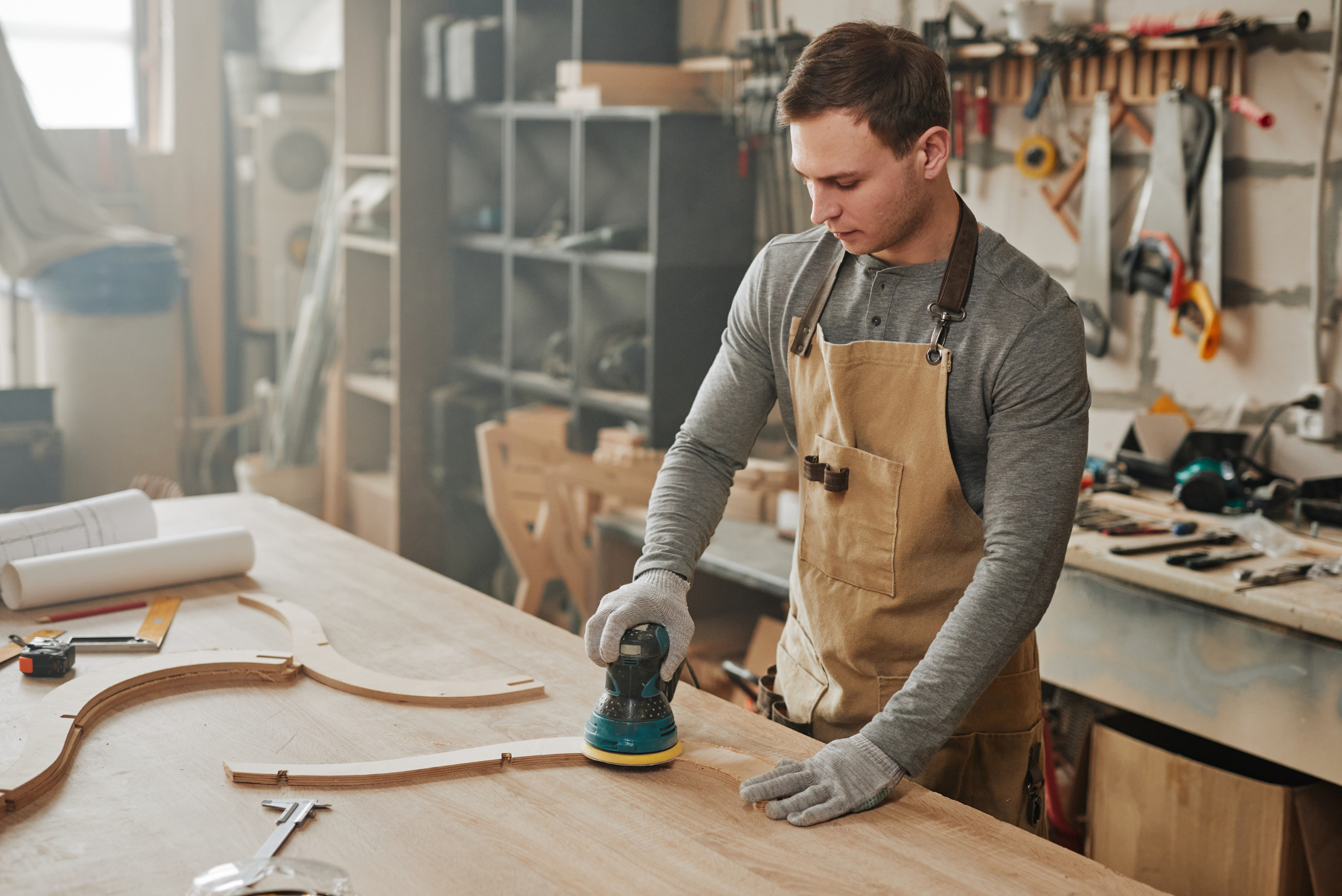 Man using orbital sander on wood project.