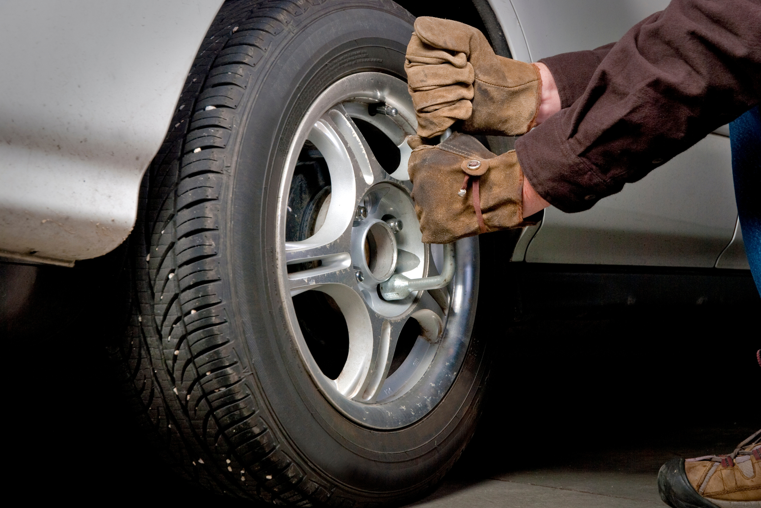 Man removing lug nuts off a vehicle's wheel.