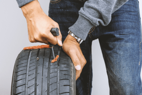 Man using a tire plug kit.