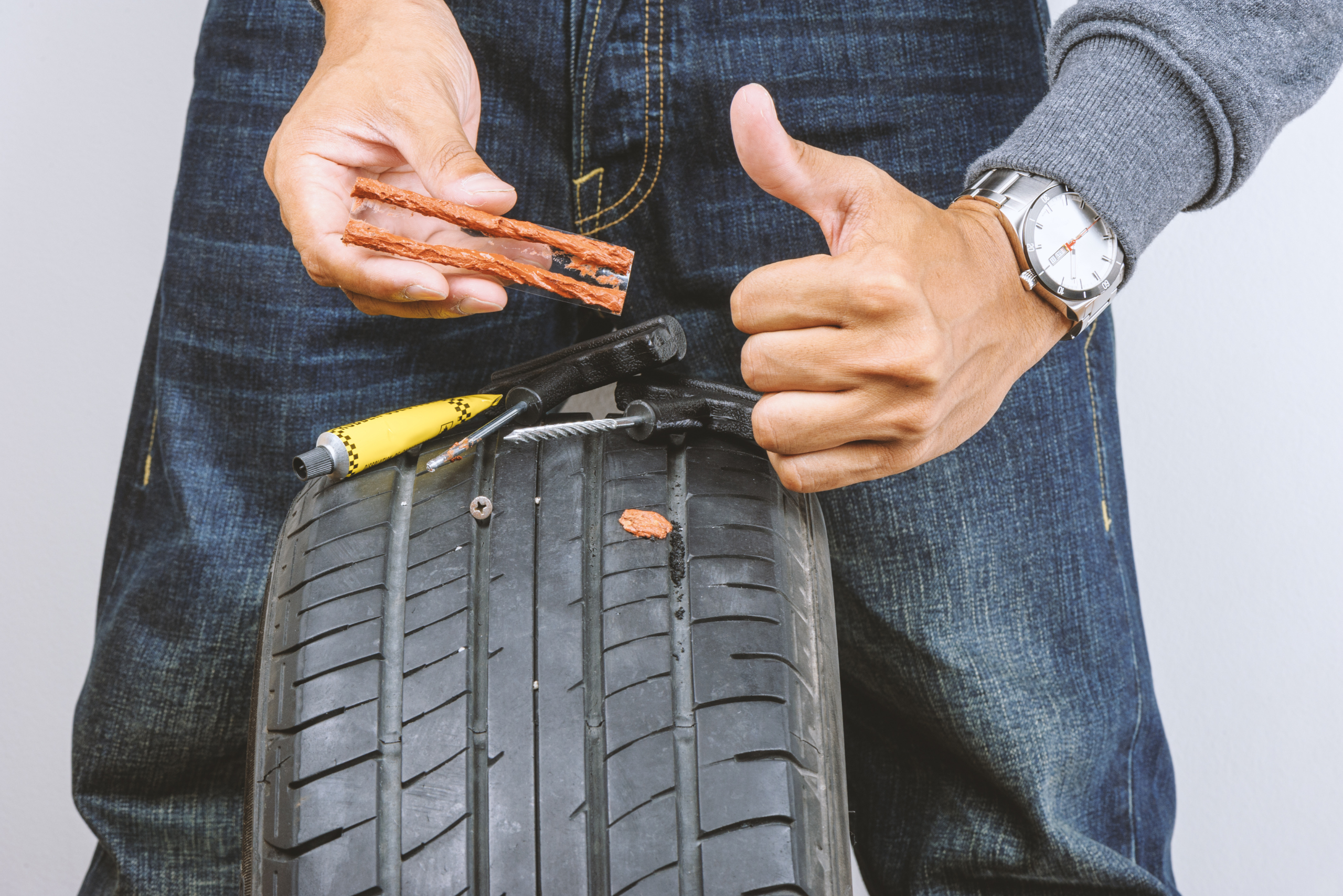 Man using a tire plug kit.