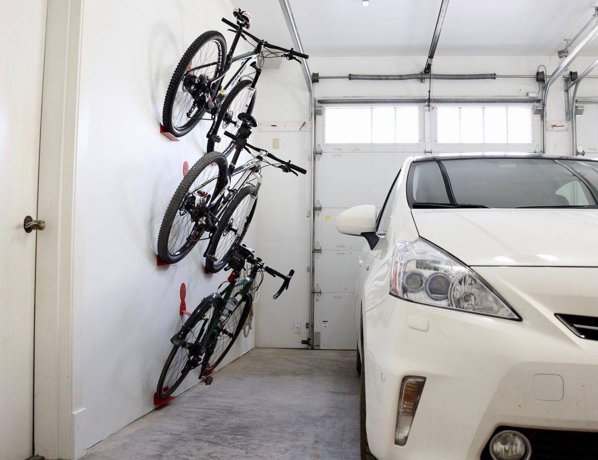 Car in garage with bikes mounted onto the wall.