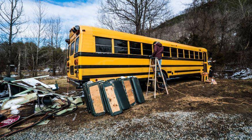 Yellow bus with materials scattered around it.