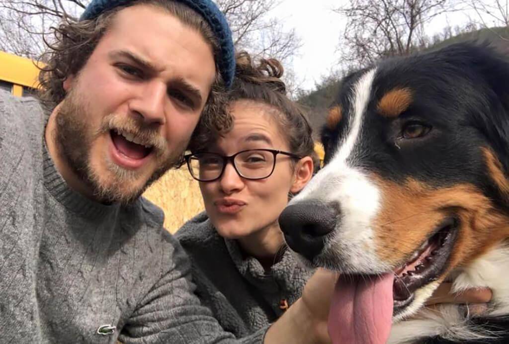 Couple posing with a dog for picture.