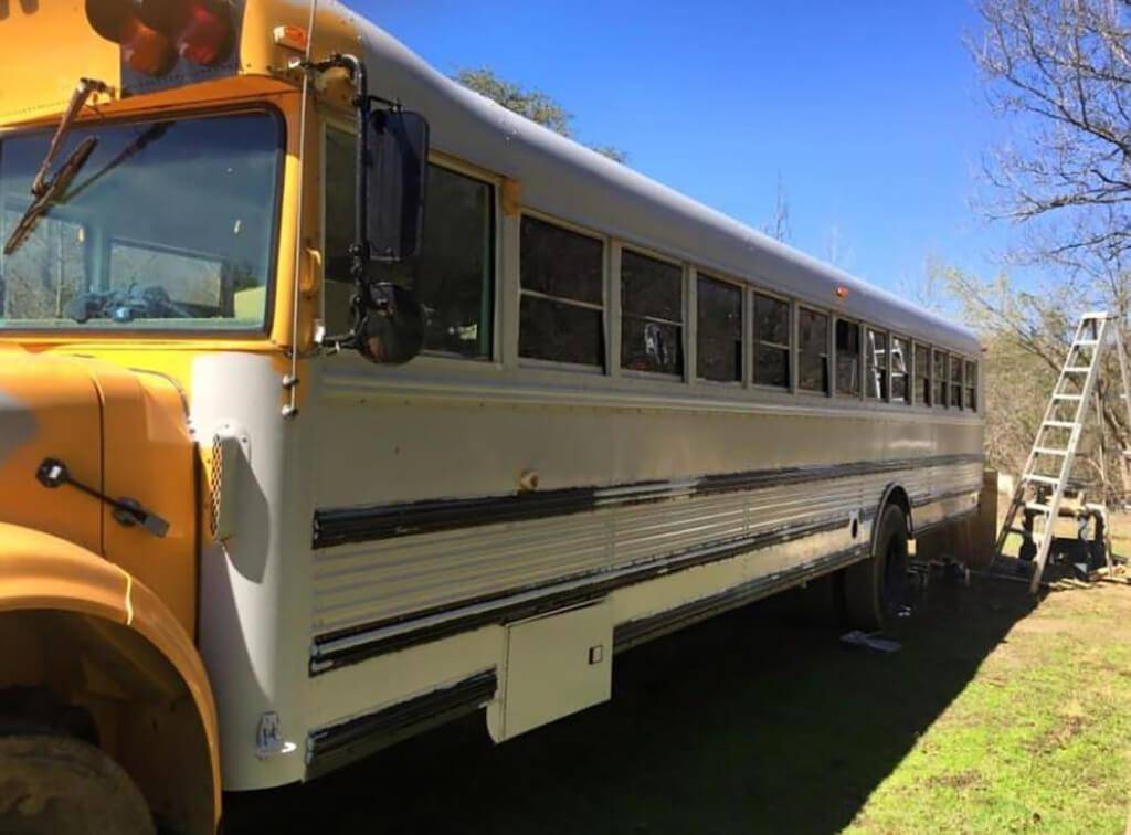 Bus getting repainted from yellow to white.