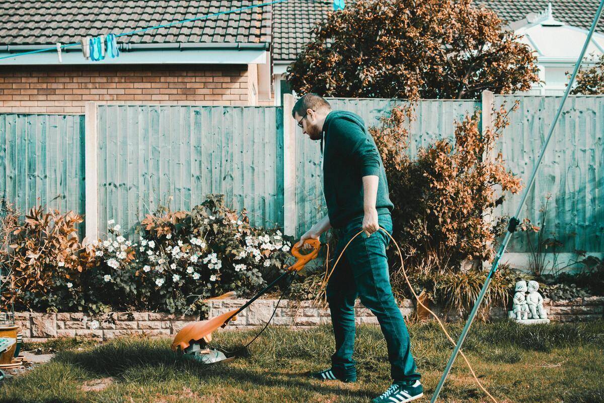 Man taking care of grass with edger.