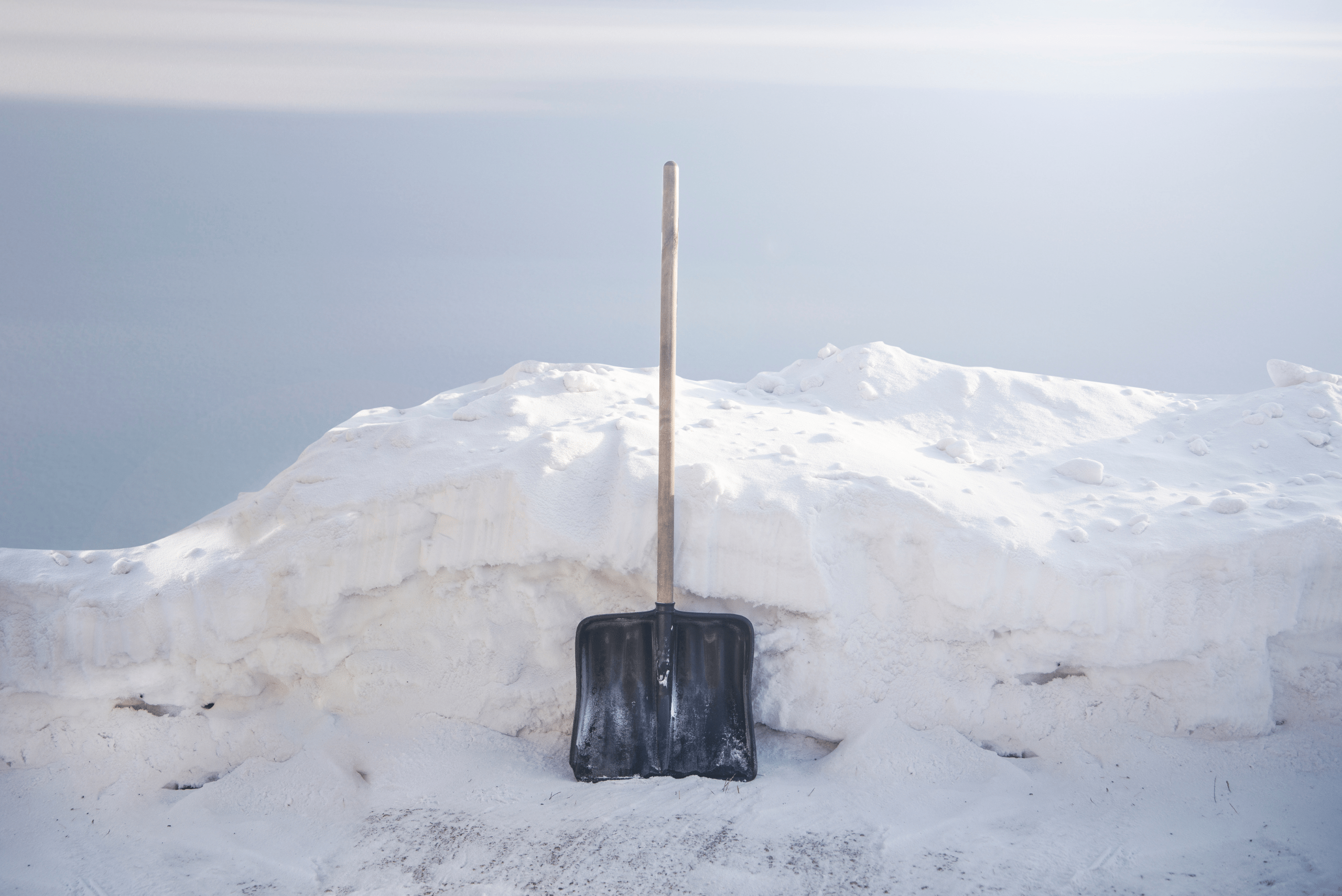 Shovel on top of a snow pile.