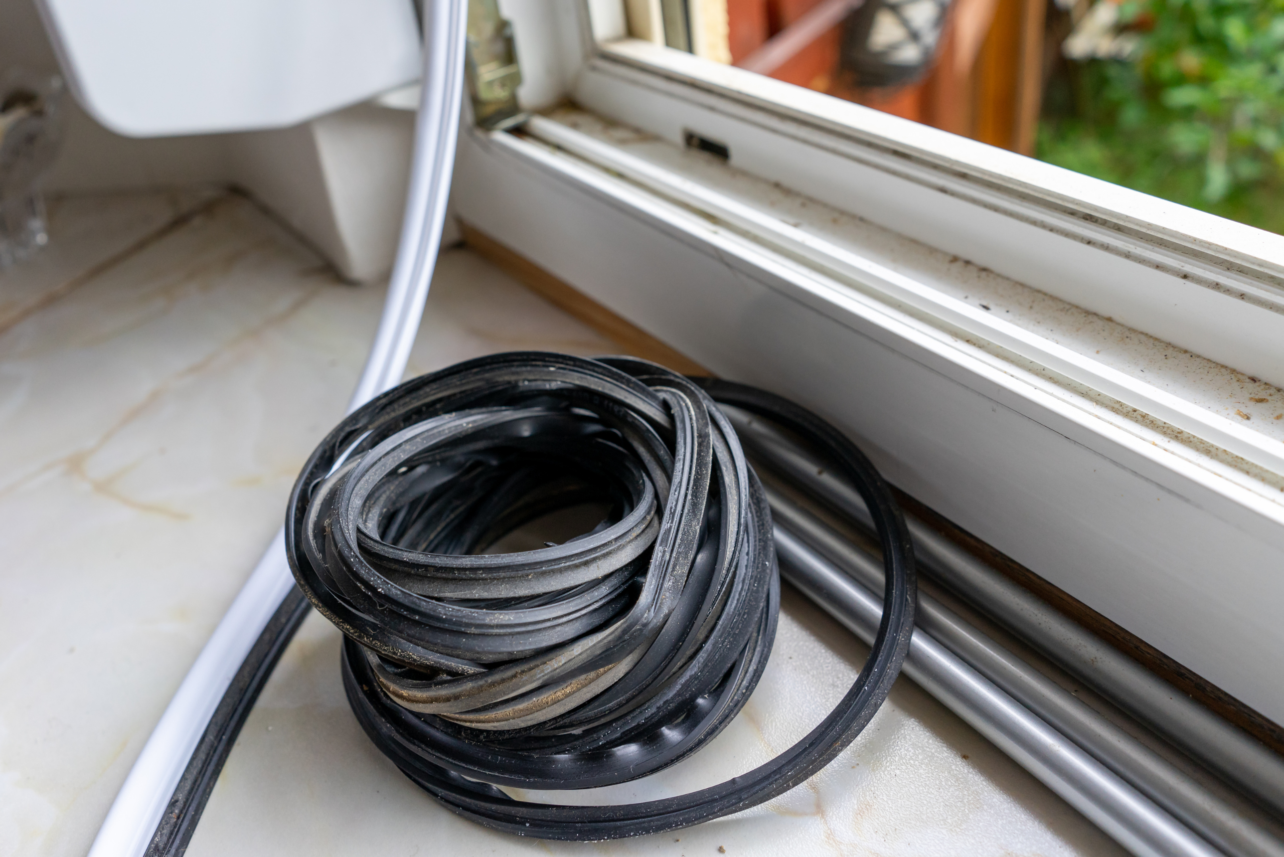 Weatherstripping in front of a window sill.