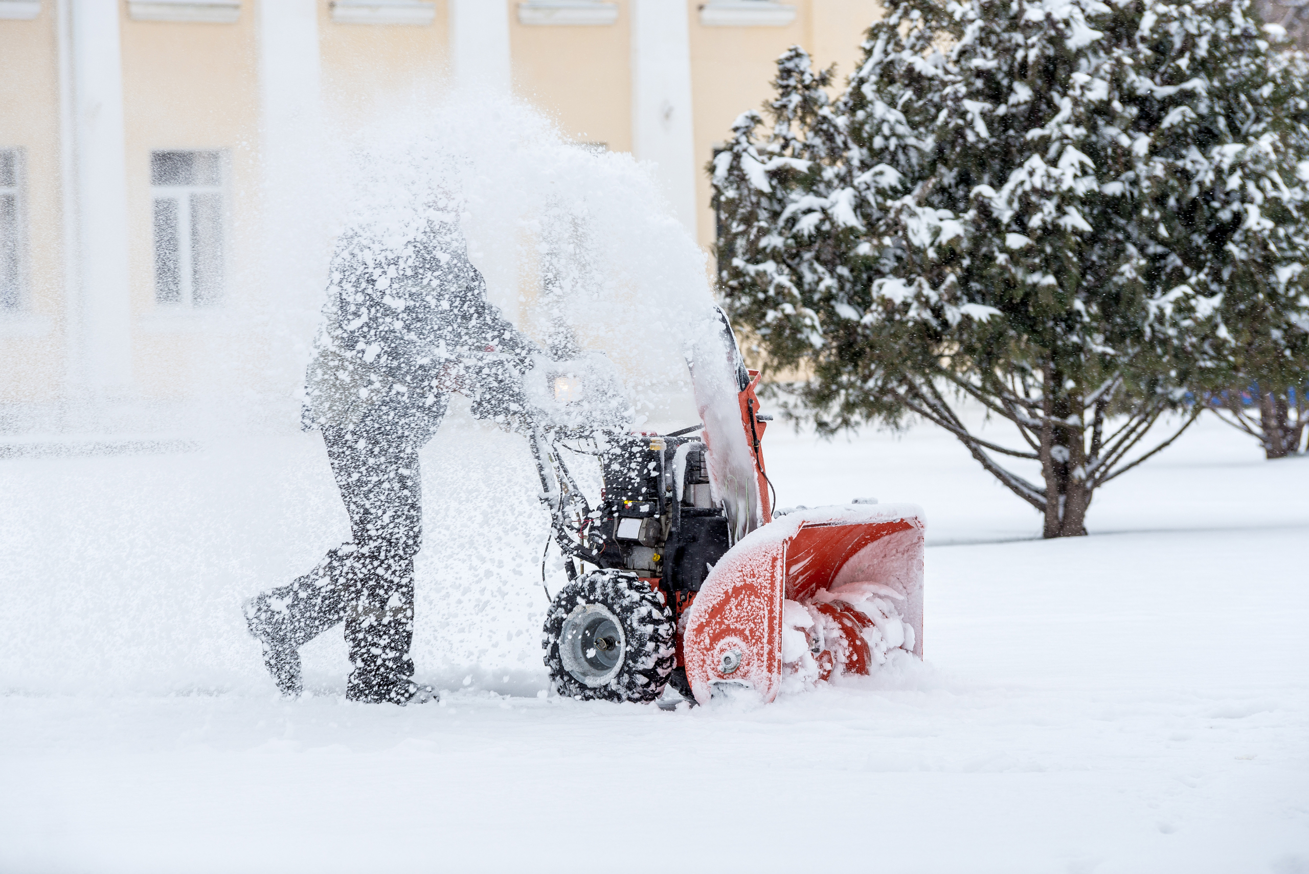 Man using a snowblower.