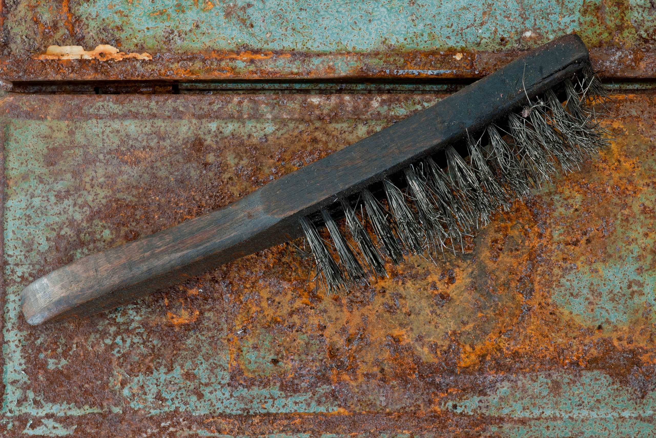 Wire brush on rusty metal.