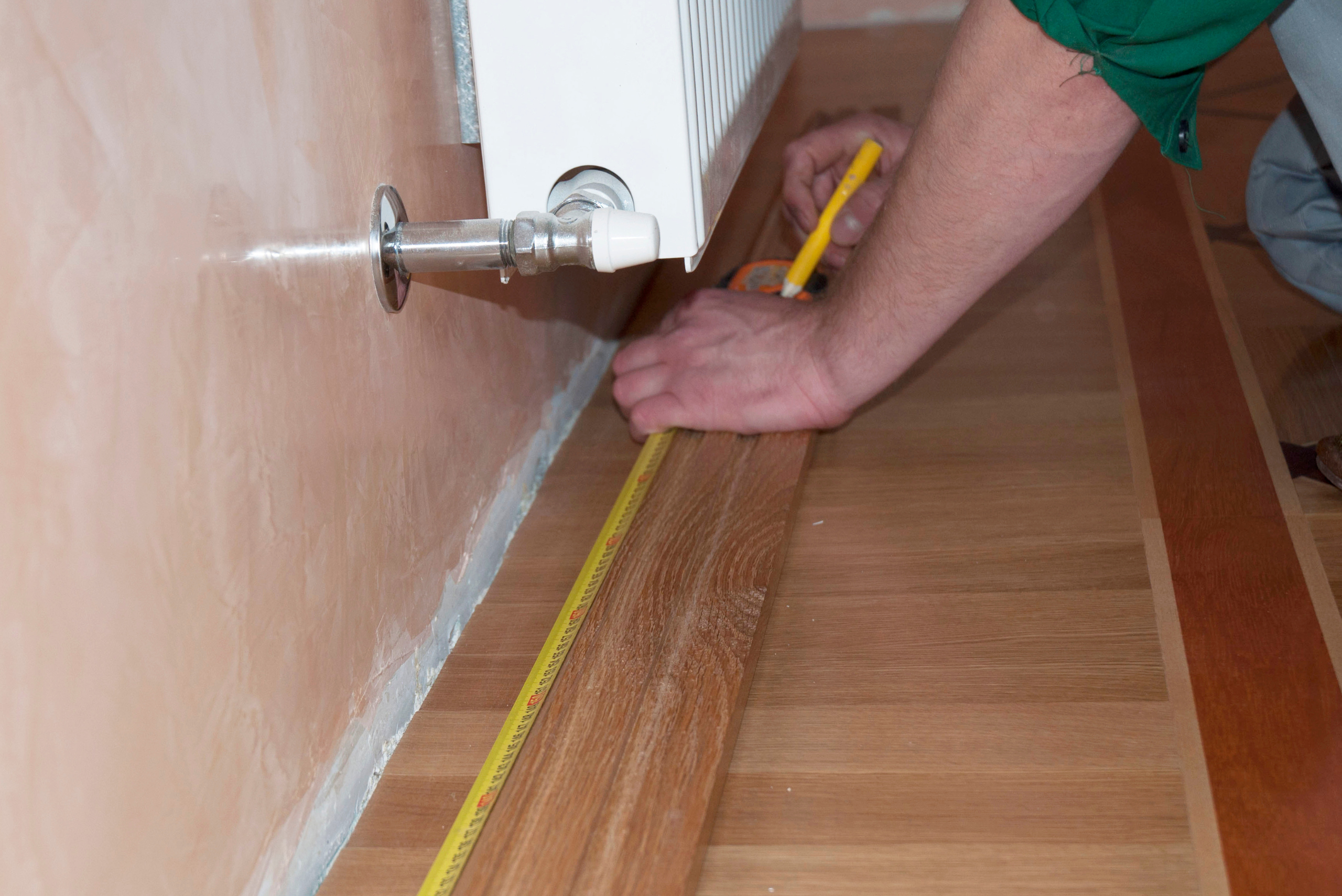 Measuring length of baseboard against wall.