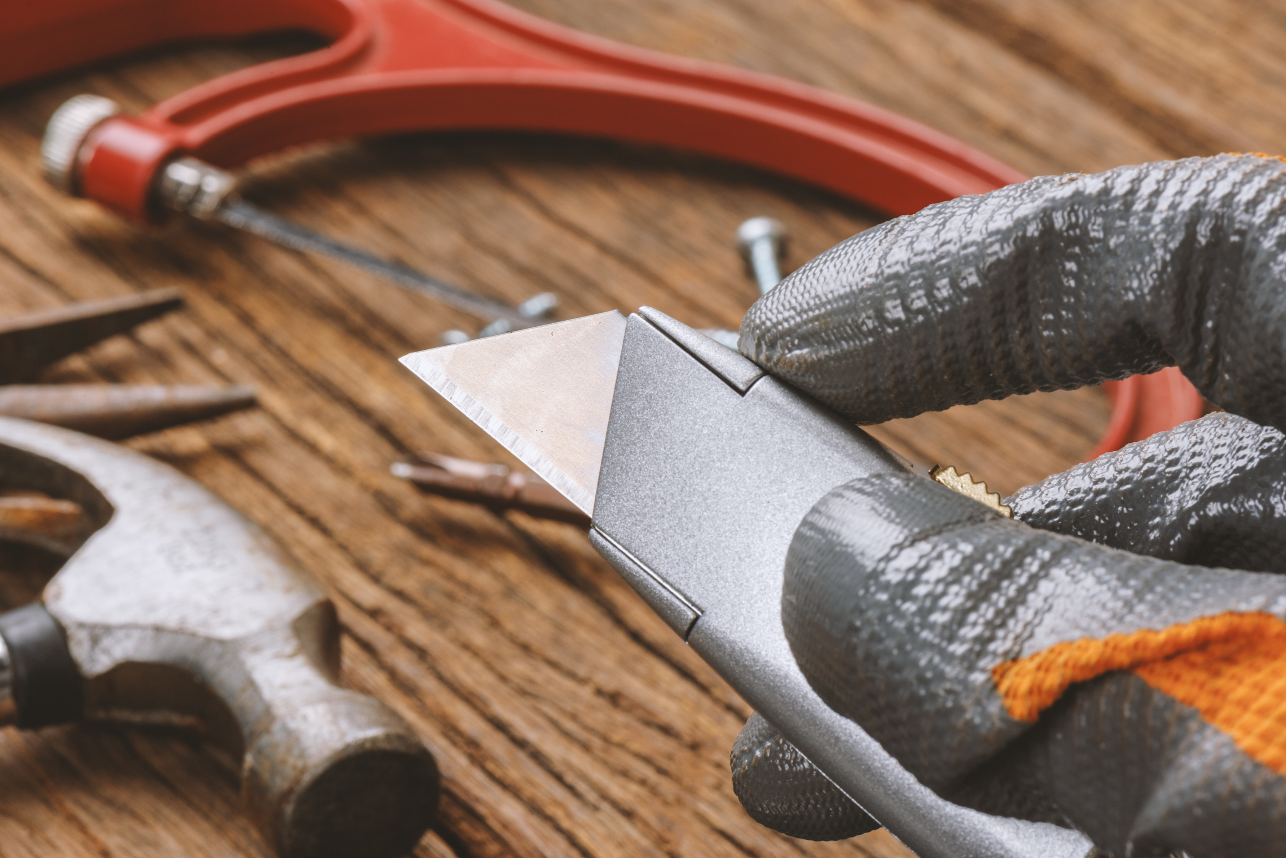 Utility knife in someone's hand with the blade out.