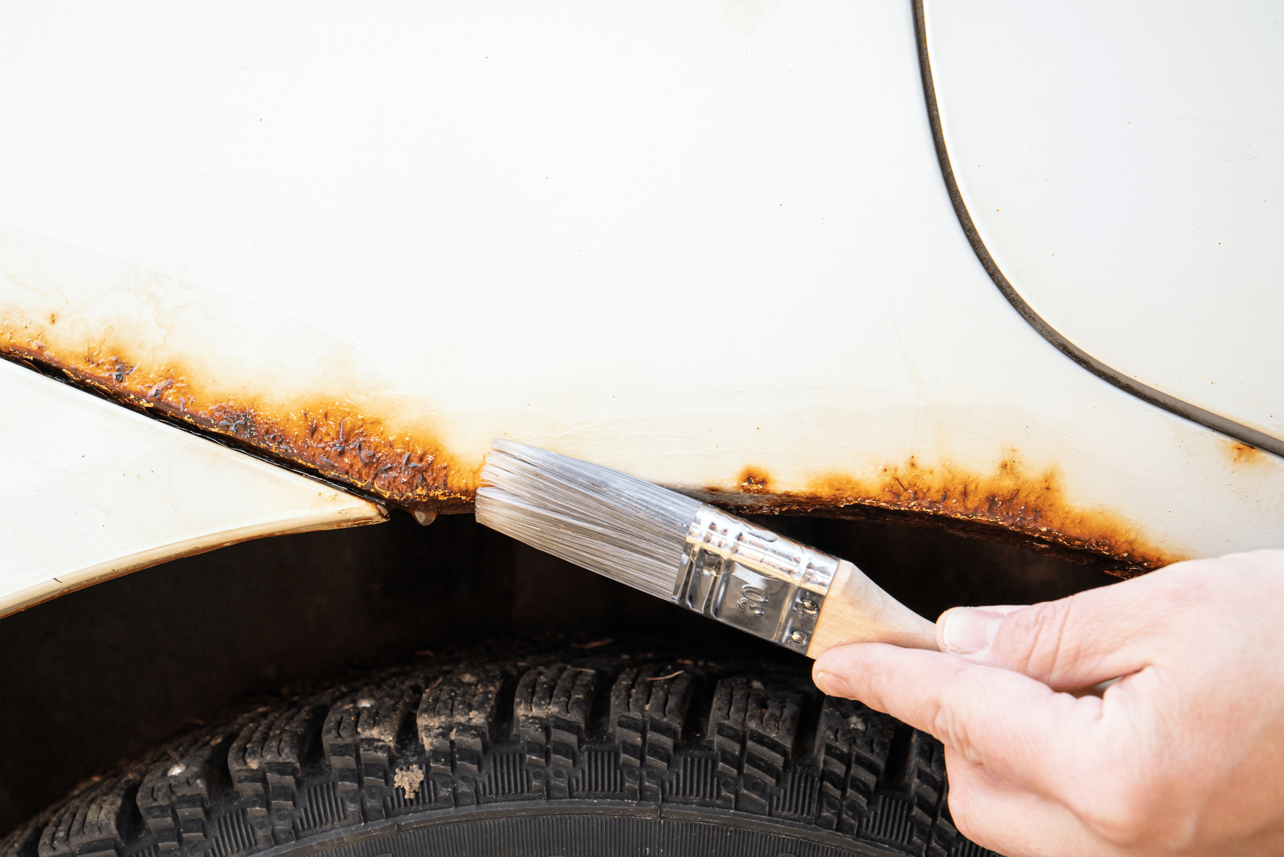 Applying rust converter using a brush.