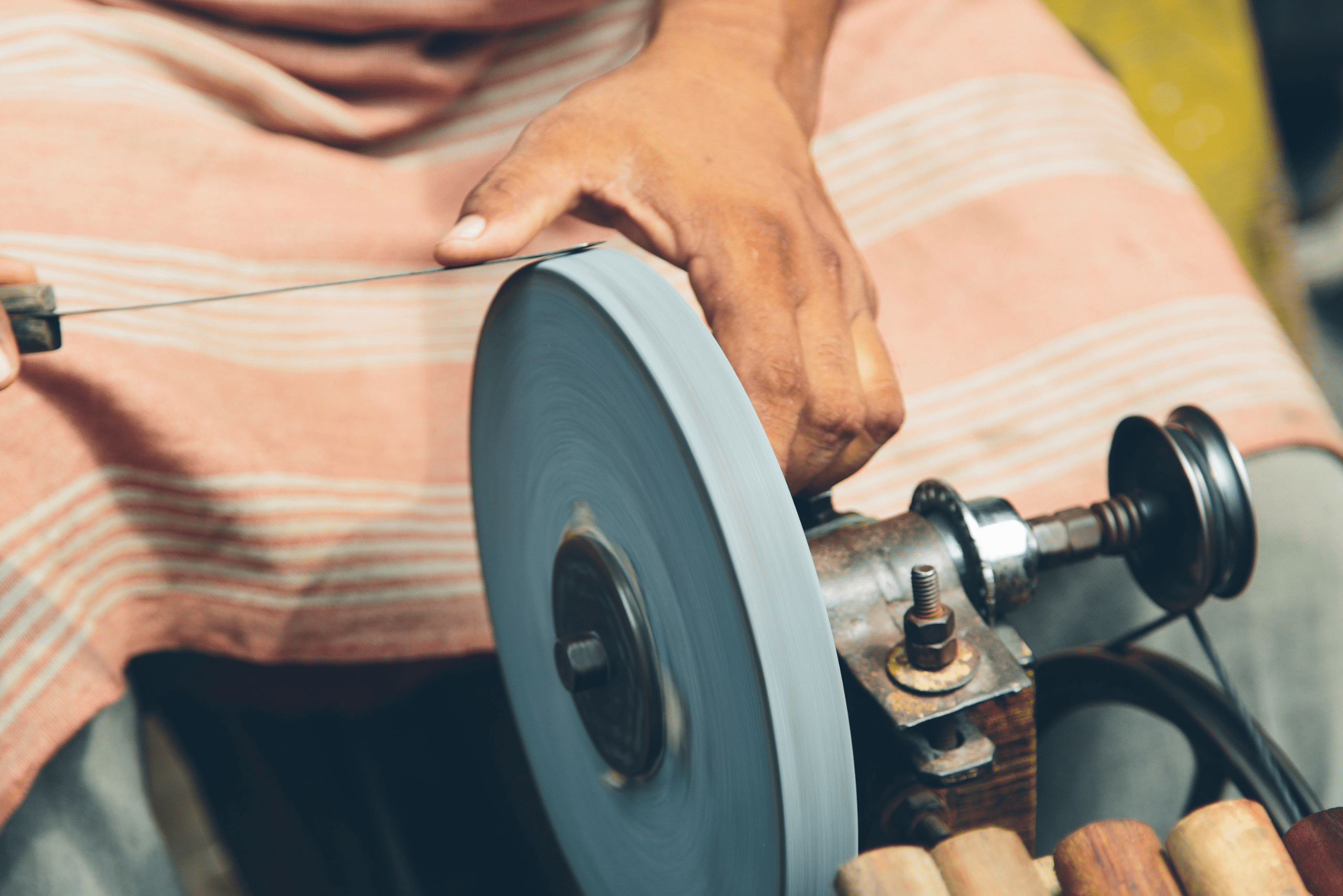 Sharpening knife on a rotating wheel.