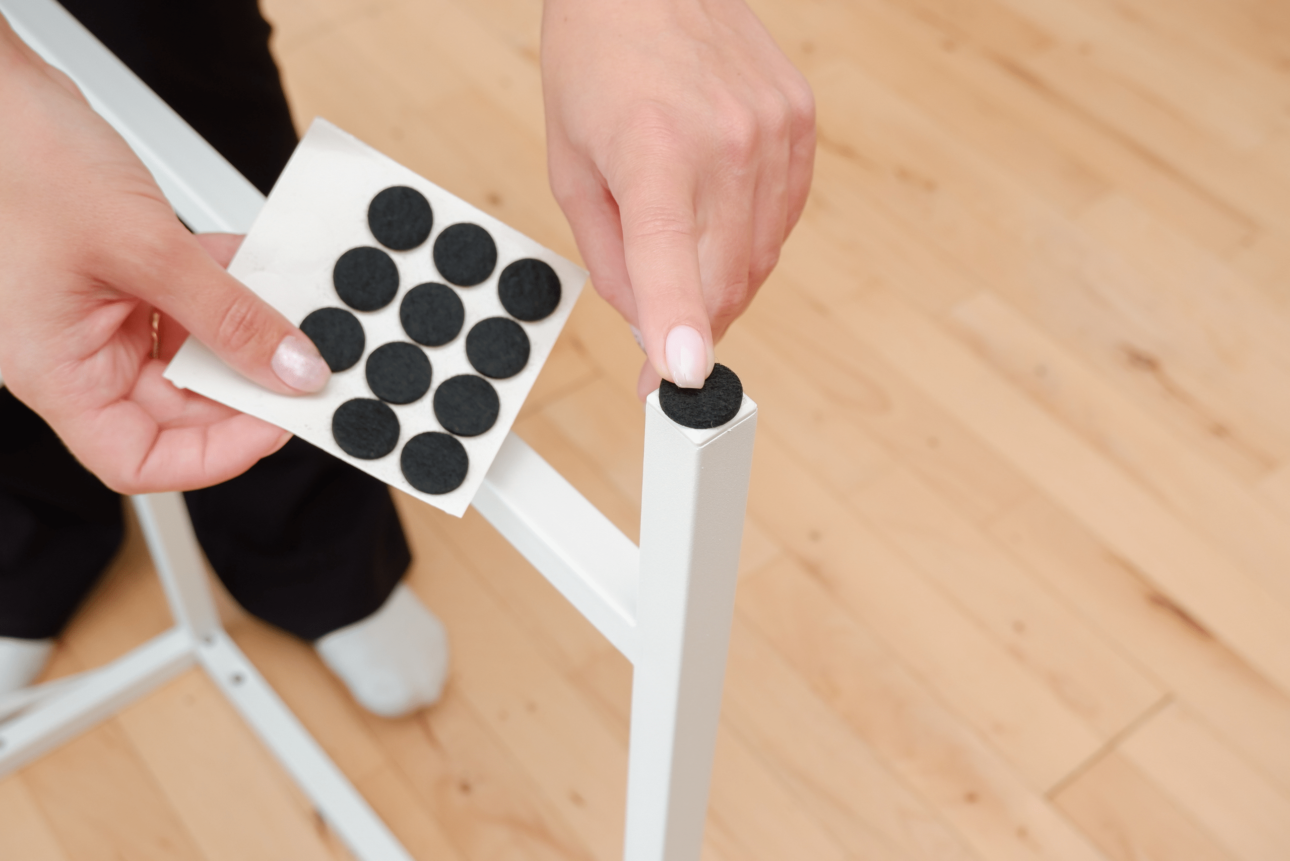 Person replacing chair leg felt pads.