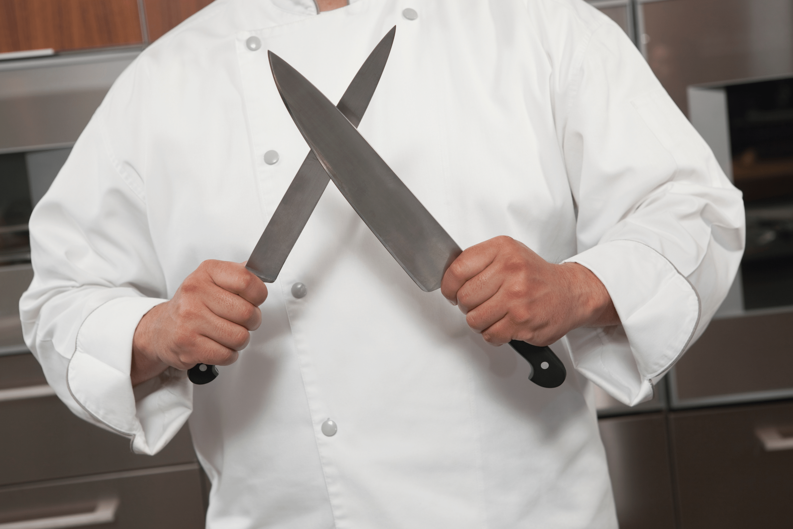 Chef holding two knives.