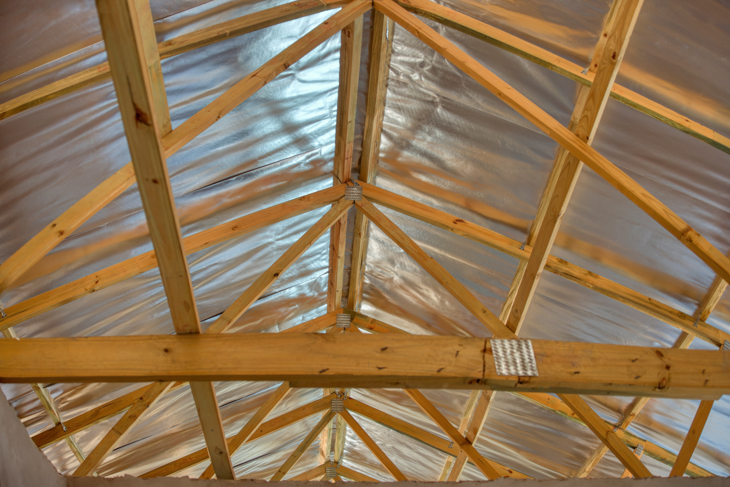 Interior of a roof covered in aluminum tape.