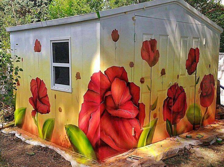 Garden shed painted with flowers on it.