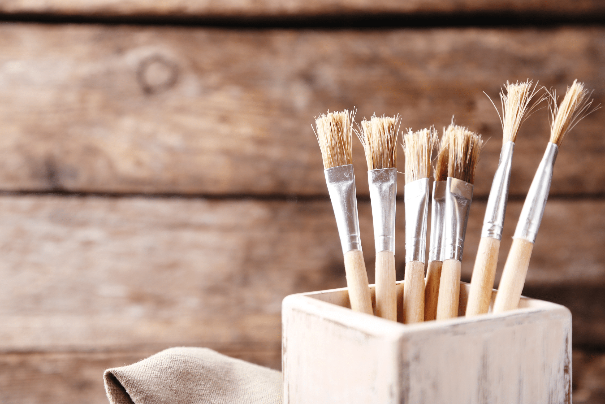 Paint brushes in a wooden holder.