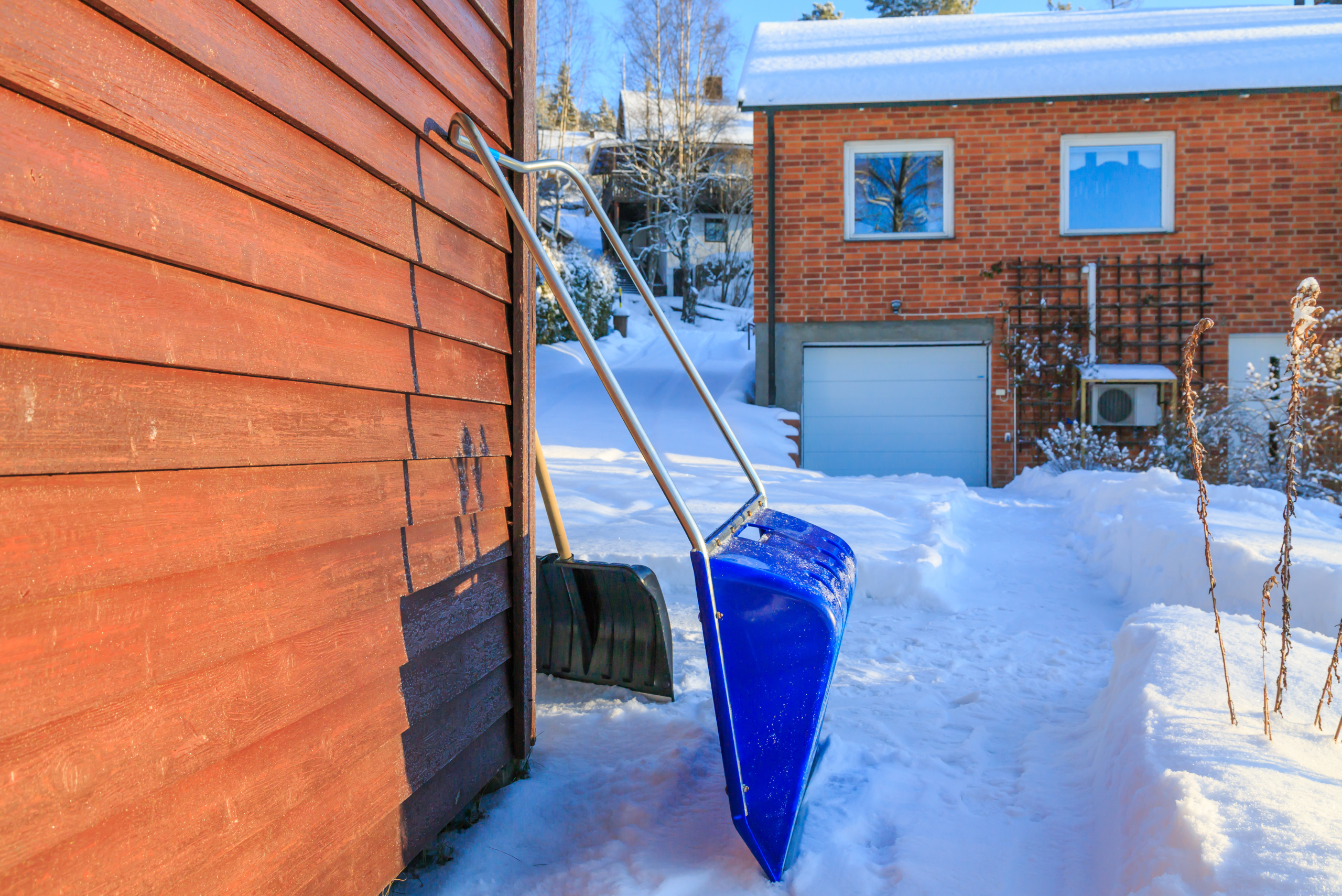 Snow shovel leaning against wall.