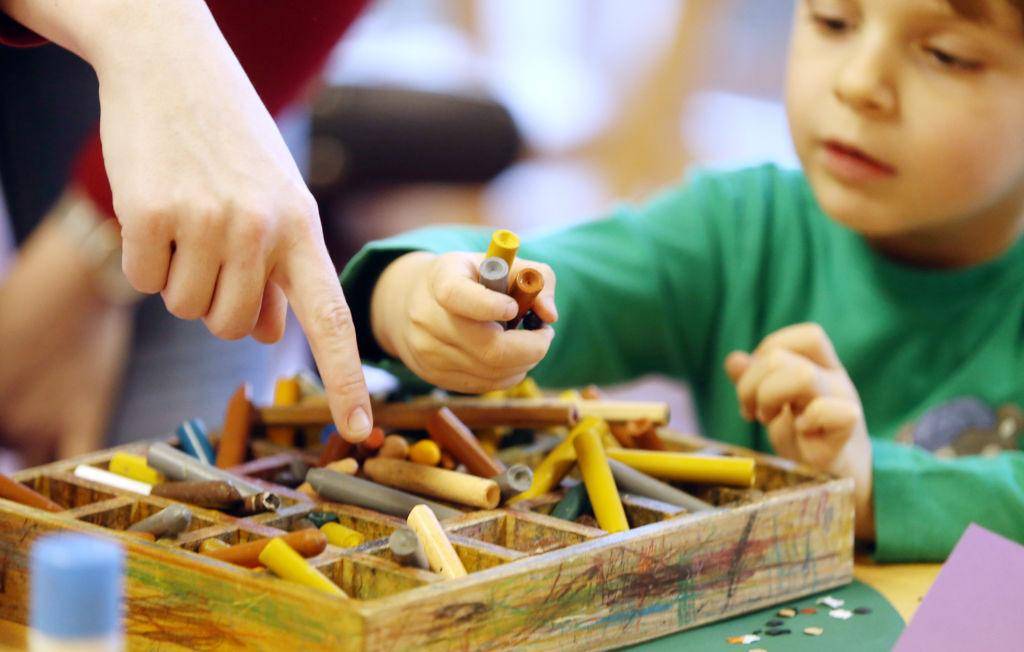 Kid playing with pencils. 