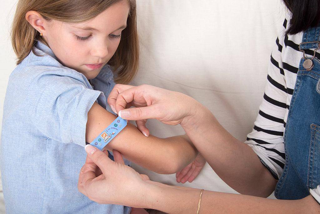 Person treating a cut on a child.