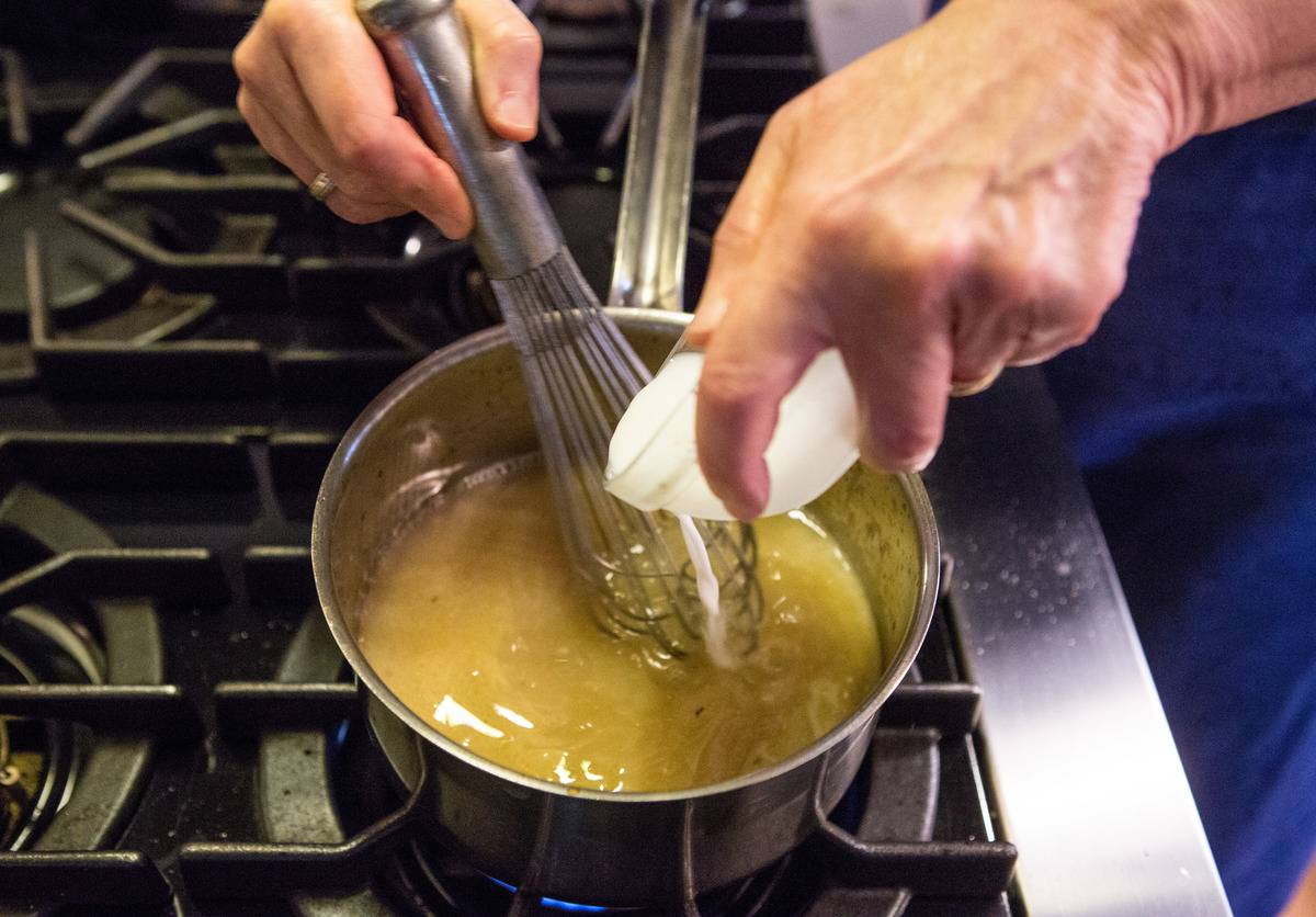 Food editor Sheryl Julian whisks cornstarch diluted with water while making gravy at her home in Watertown. 