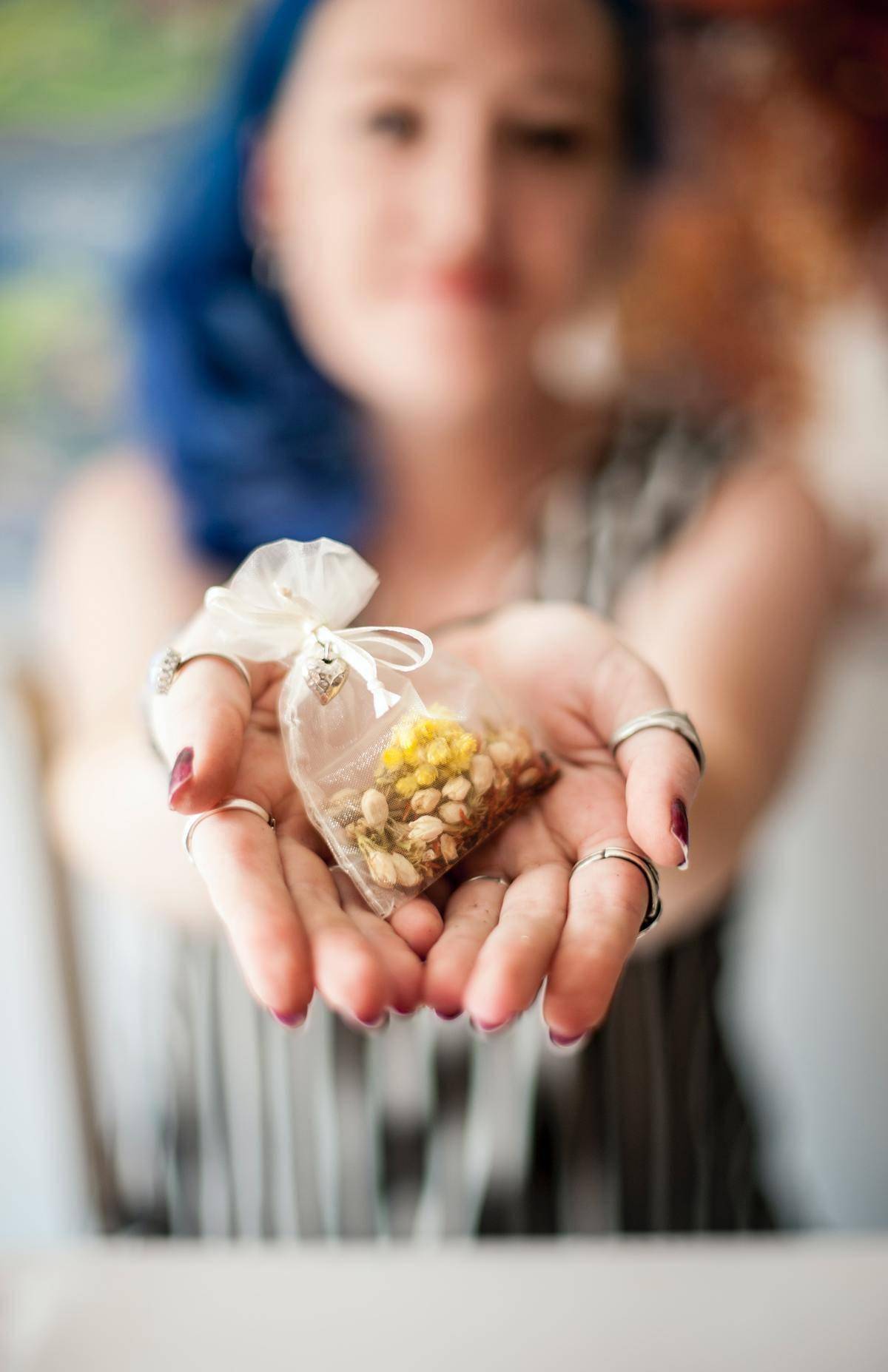 Woman holding a small mesh bag with both hands.