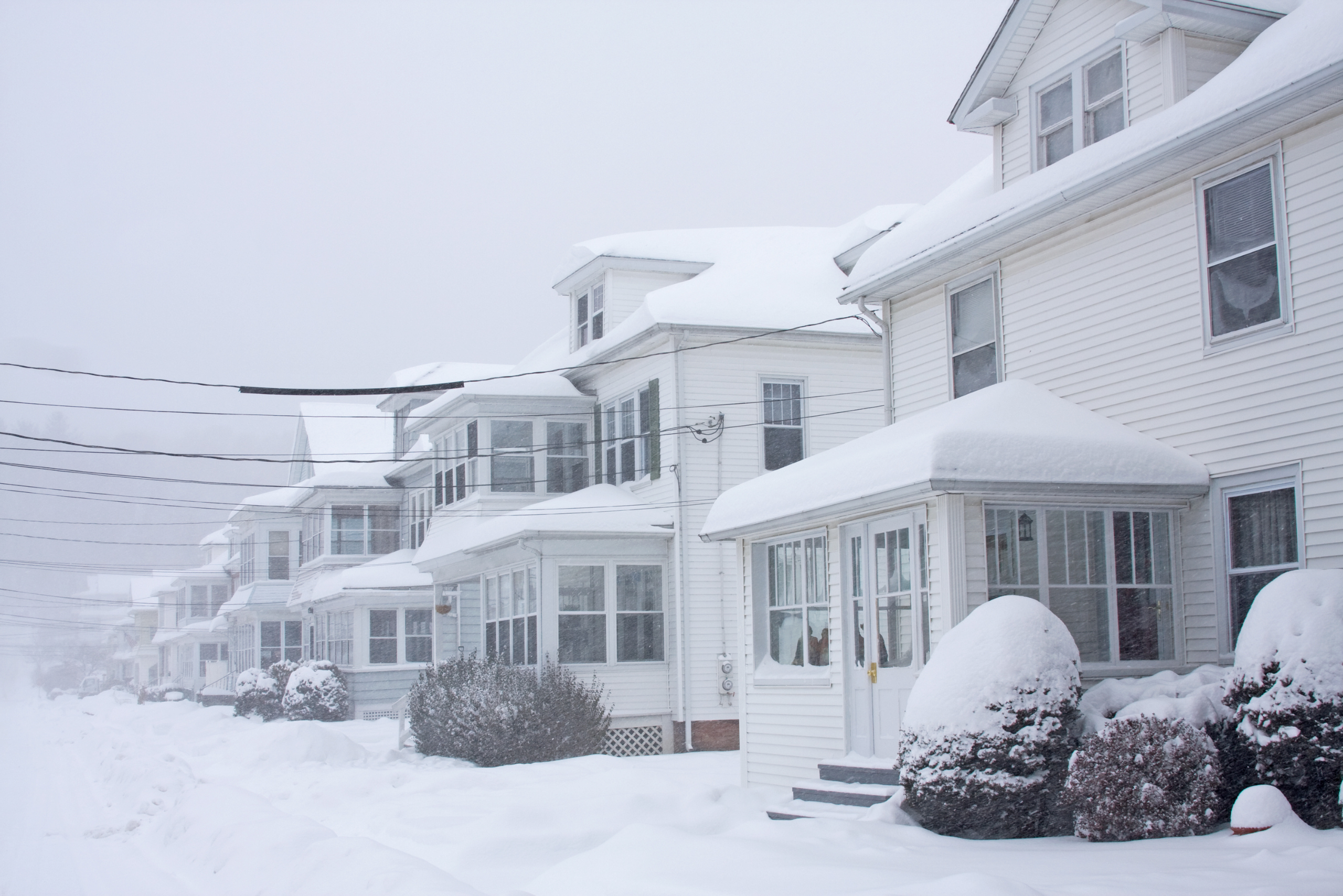 Homes in a blizzard covered in snow.