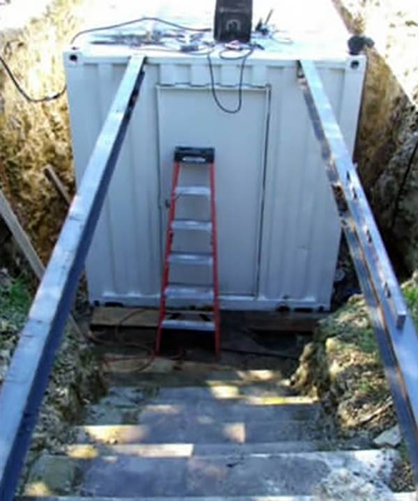 Ladder leaning on white container.