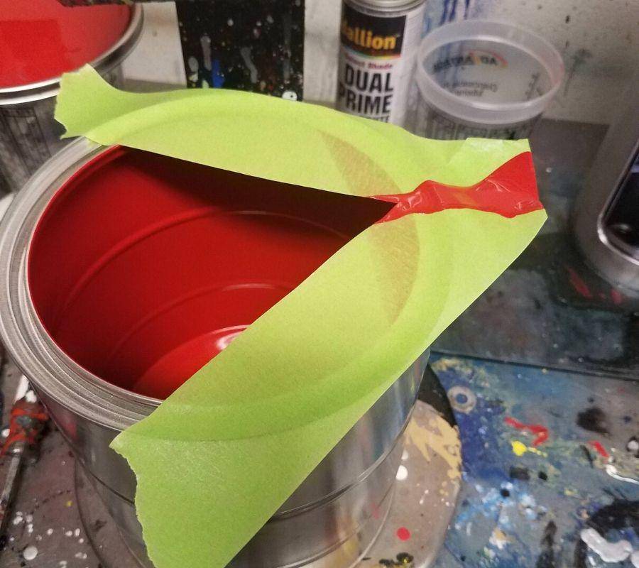 using tape to make a pour spout on a bucket of paint