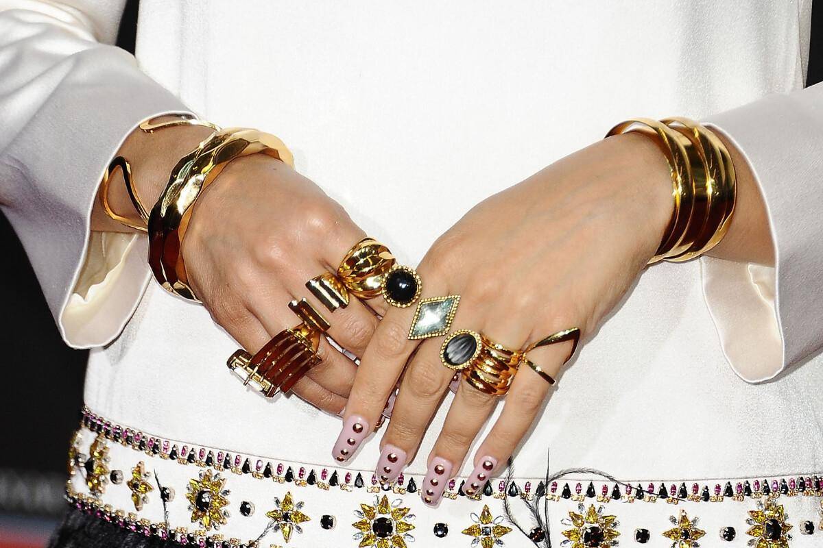 Woman's hands wearing various rings.